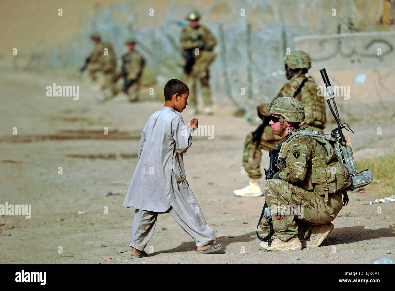 Le Sgt. Cerveau Reid, de la Garde nationale de l'Alaska, des entretiens avec un enfant afghan local lors d'une patrouille à pied à un ministère des Travaux publics le 8 août 2012, l'installation, à Kandahar, en Afghanistan. Banque D'Images