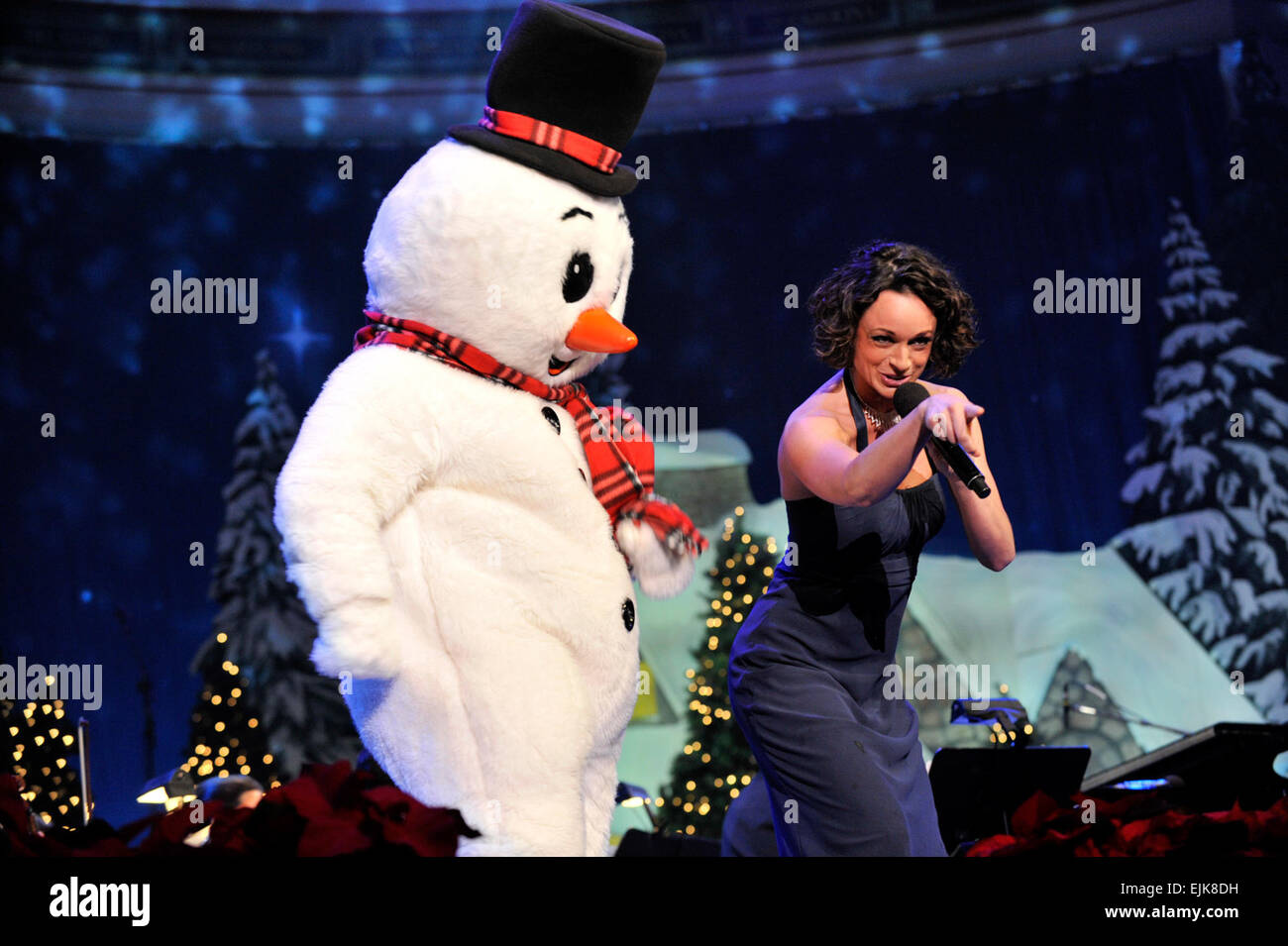 Le sergent-major de l'armée américaine. Martha Krabill chante un medley de Noël pour les enfants à côté de Frosty the Snowman, au cours de l'armée américaine District militaire de Washington Maison de vacances annuel Festival Concert à DAR Constitution Hall de Washington, D.C., 10 décembre 2010. Krabill est une chanteuse soprano et membre du U.S. Army Band Pershing propre. Le s.. Teddy Wade Banque D'Images