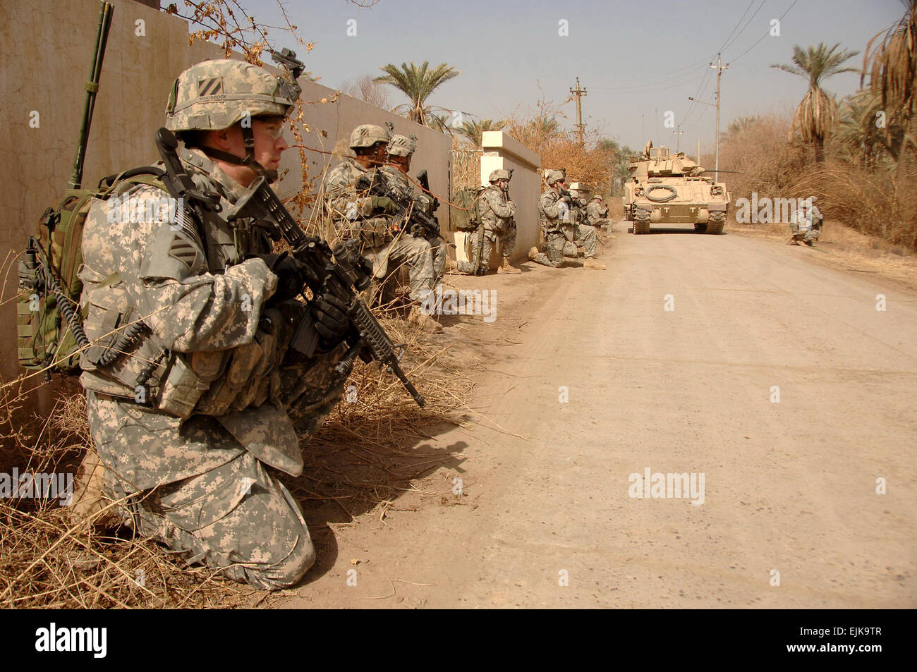 Les soldats de l'Armée américaine à partir de la Compagnie Alpha, 1er Bataillon, 15e Régiment d'infanterie, 3e Brigade Combat Team lourd, 3ème Division d'infanterie prendre un genou pour rechercher l'ennemi avant d'une opération de compensation avec les abna'a Al Iraq Fils de l'Irak par l'intermédiaire d'un groupe de petits villages au sud de Salman Pak, l'Iraq, 16 février 2008. Le village est connu pour avoir récemment été occupé par les insurgés. Le Sgt. Timothy Kingston publié Banque D'Images