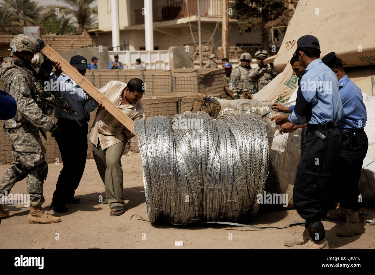 Des policiers irakiens et les soldats de l'armée américaine renfort déplacer fournitures livrées à la police irakienne Abayachi station dans la province de l'Irak de Tarmiya, 30 mars 2008. Tech. Le Sgt. William Greer publié Banque D'Images