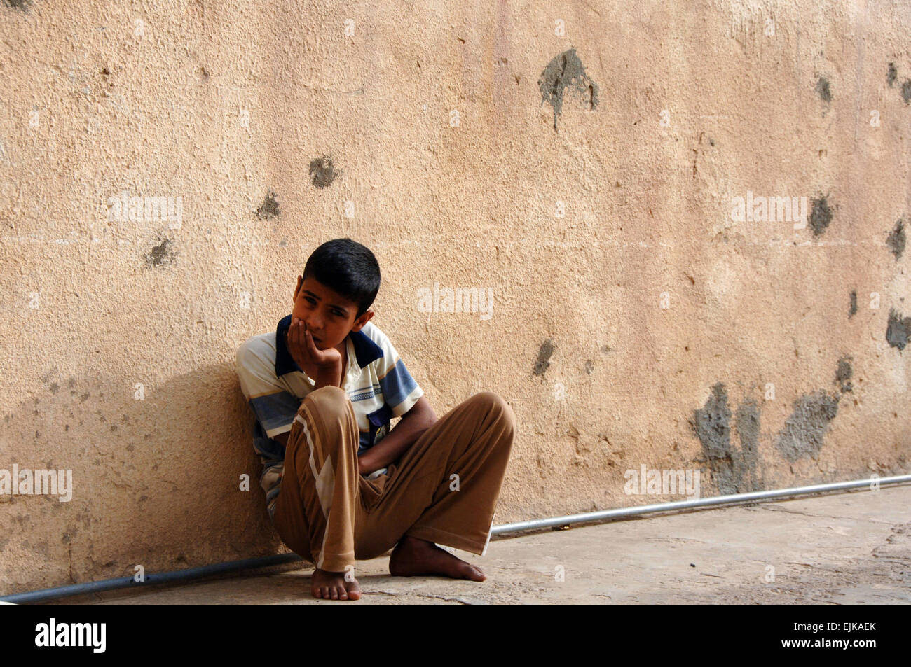 Un enfant iraquien attend que les soldats de l'Armée américaine à partir de la 3e Escadron, 2e régiment de cavalerie recherchez son domicile pour connaître les suspects dans Muqdadiyah, l'Iraq, le 6 avril 2008. La FPC. Charles Probst publié Banque D'Images