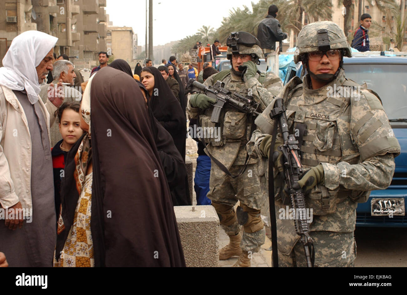 Les soldats de l'Armée américaine à partir de la troupe, 4e Escadron, 9e régiment de cavalerie, 2e Brigade Combat Team, 1re Division de cavalerie, assurer la sécurité des résidents d'Haïfa Street reçoivent de l'aide alimentaire et à Bagdad, l'Iraq, le 13 février 2007. La CPS. Olanrewaju Akinwunmi Banque D'Images