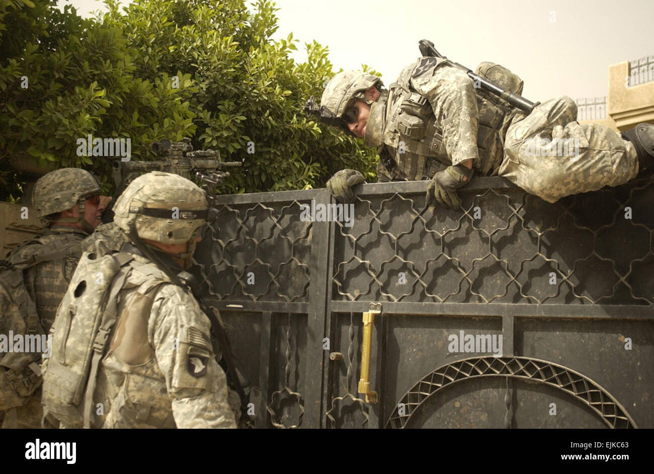 Un soldat de l'armée américaine de la Compagnie Alpha, 2e Bataillon, 3e Régiment d'infanterie, saute par dessus une barrière pour le déverrouiller pour rechercher une maison à Rashid, l'Iraq, le 2 juin 2007. Le Sgt. Tierney Nowland Banque D'Images