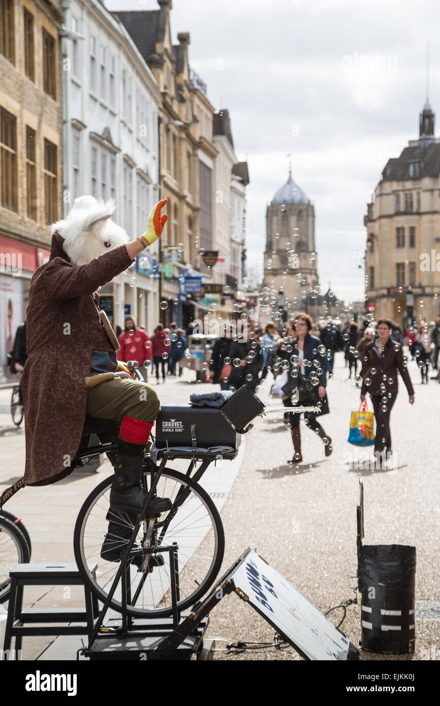 Oxford, UK. Mar 27, 2015. Un artiste de rue souffle bulles qui sont apprécié par des gens de passage sur Cornmarket Street, Oxford, Crédit : CBCK-Christine/Alamy Live News Banque D'Images