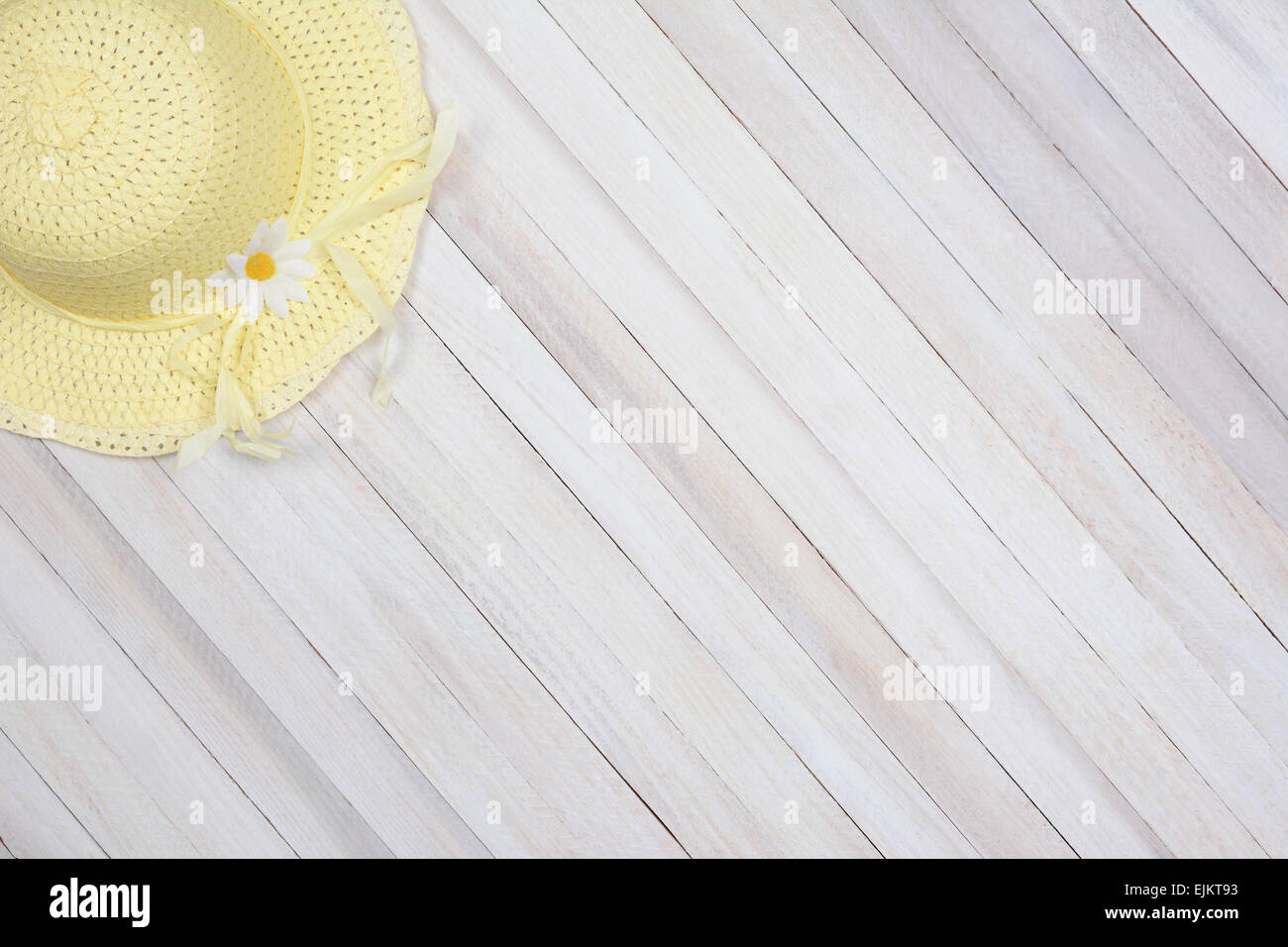 High angle shot d'un soleil jaune bonnet sur une surface en bois rustique. La hat se trouve dans le coin supérieur gauche du cadre laissant place f Banque D'Images