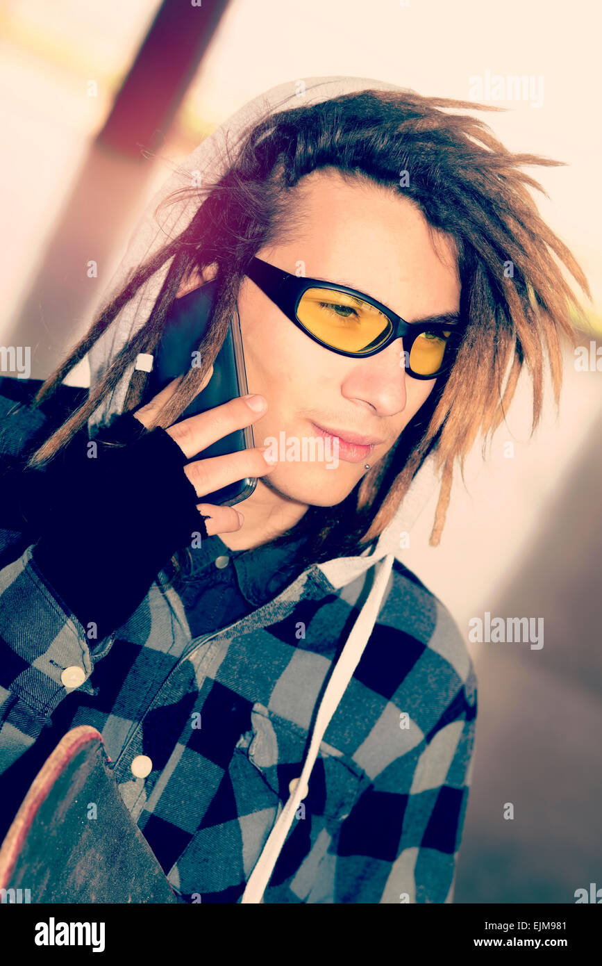 Portrait de jeune homme avec des cheveux rasta dans un concept de vie filtre appliqué à chaud Banque D'Images