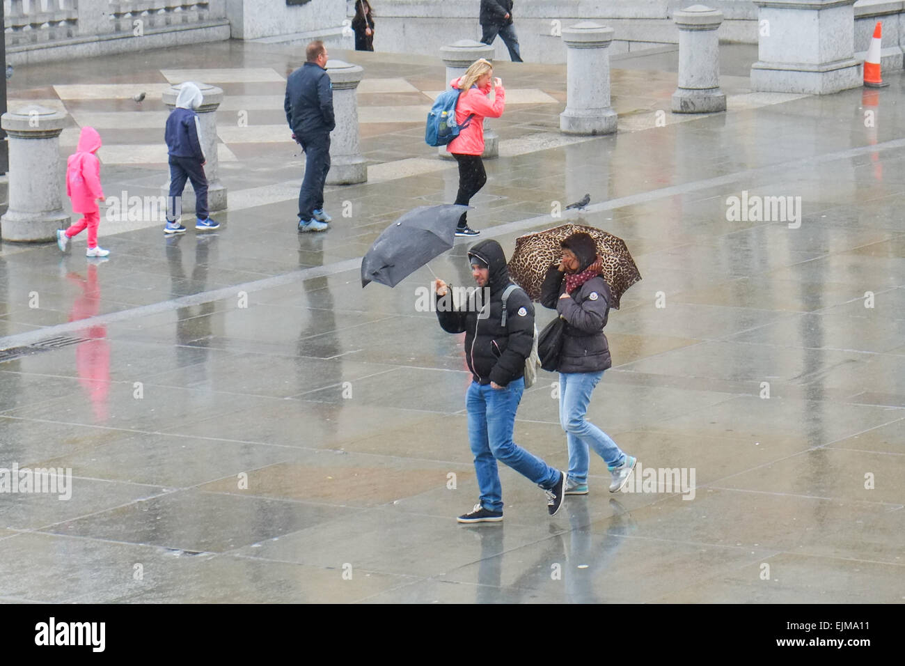 Trafalgar Square, Londres, Royaume-Uni. 29 mars 2015. Météo France : Squally gratuites envoyer les touristes d'exécution pour couvrir dans le centre de Londres. Crédit : Matthieu Chattle/Alamy Live News Banque D'Images