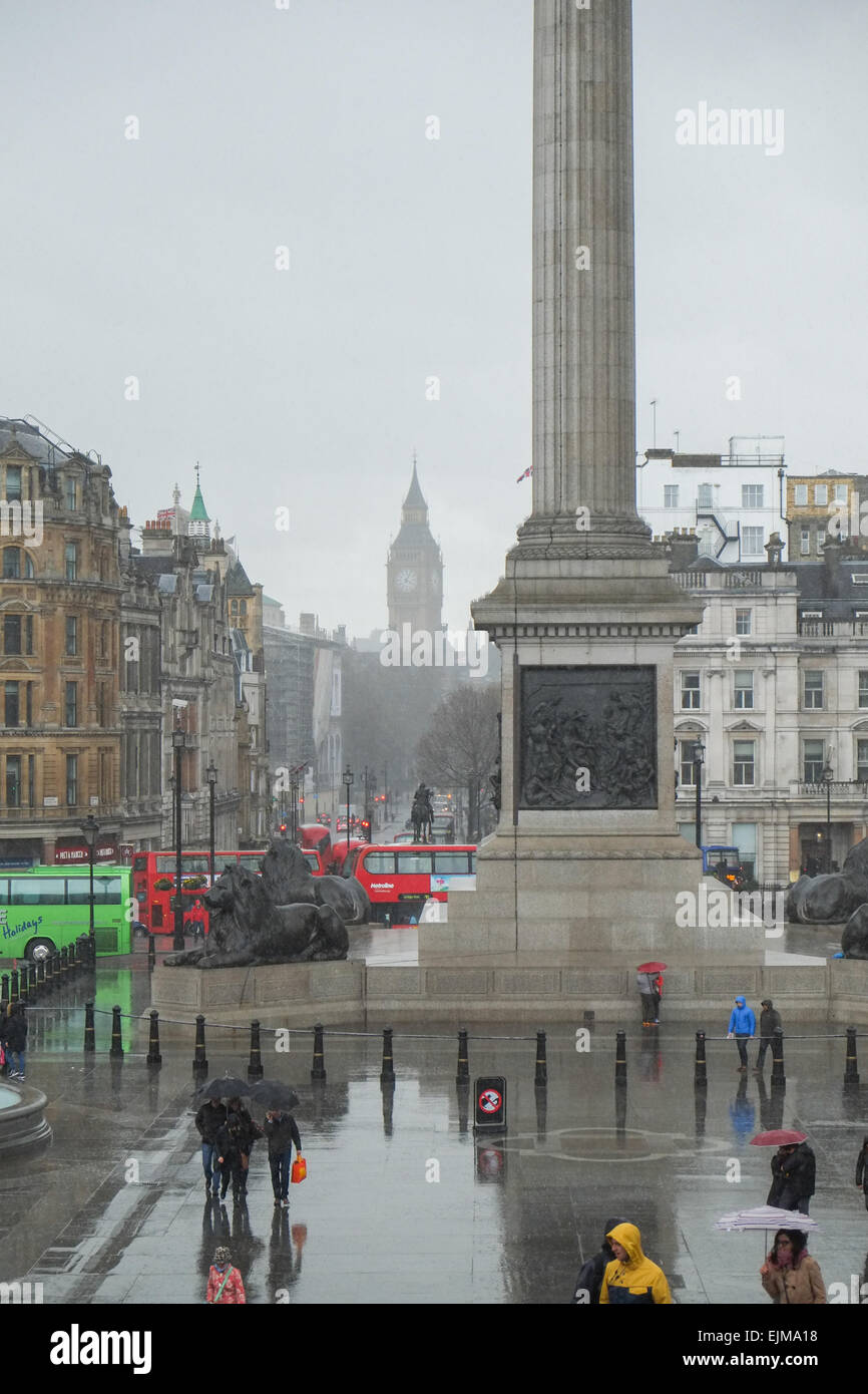 Trafalgar Square, Londres, Royaume-Uni. 29 mars 2015. Météo France : Squally gratuites envoyer les touristes d'exécution pour couvrir dans le centre de Londres. Crédit : Matthieu Chattle/Alamy Live News Banque D'Images