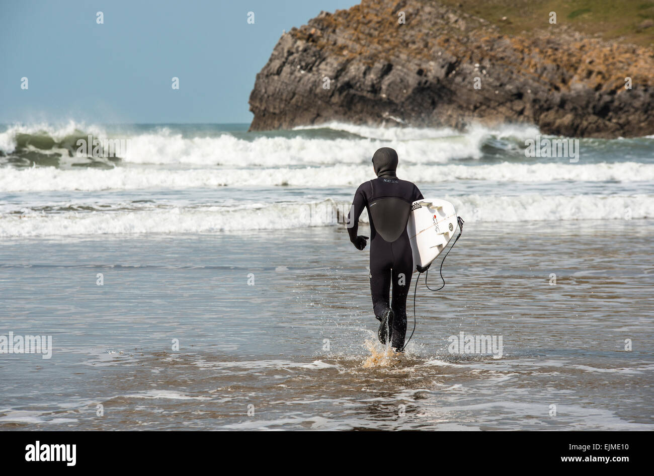 Surfer les vagues sur la position de rhossili beach sur la péninsule de Gower South Wales UK Banque D'Images