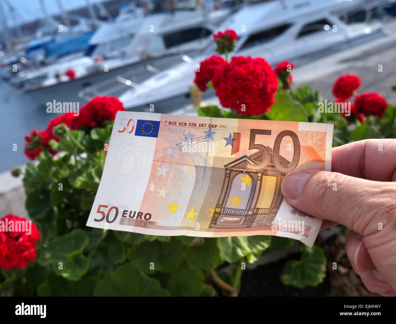 Euro note UE vacances zone euro €50 euros Euro monnaie change valeur à l'étranger main tenue dans les yachts de luxe et port de plaisance lieu de voyage derrière Banque D'Images
