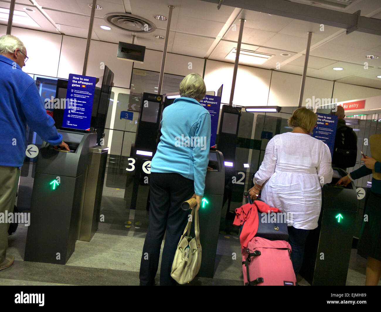 Des portes de contrôle aux frontières du Royaume-Uni pour les passeports électroniques biométriques de l'UE à l'aéroport de Londres Gatwick, avec les passagers à l'arrivée de la numérisation leur passeport Banque D'Images