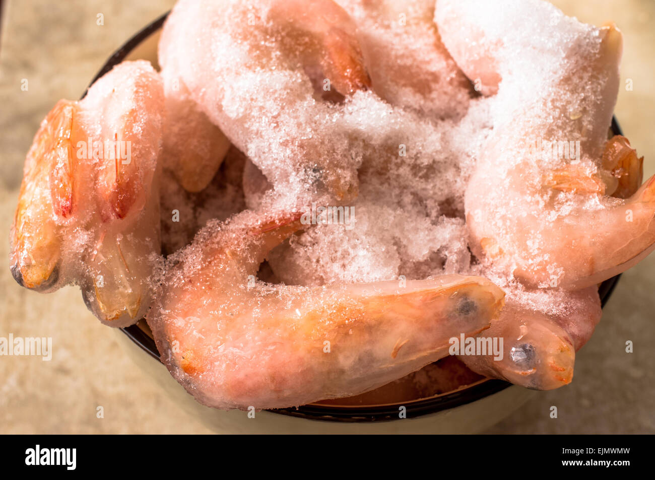 Neige sur le couvert de glace gelé la crevette rose dans une coupe d'argile Banque D'Images