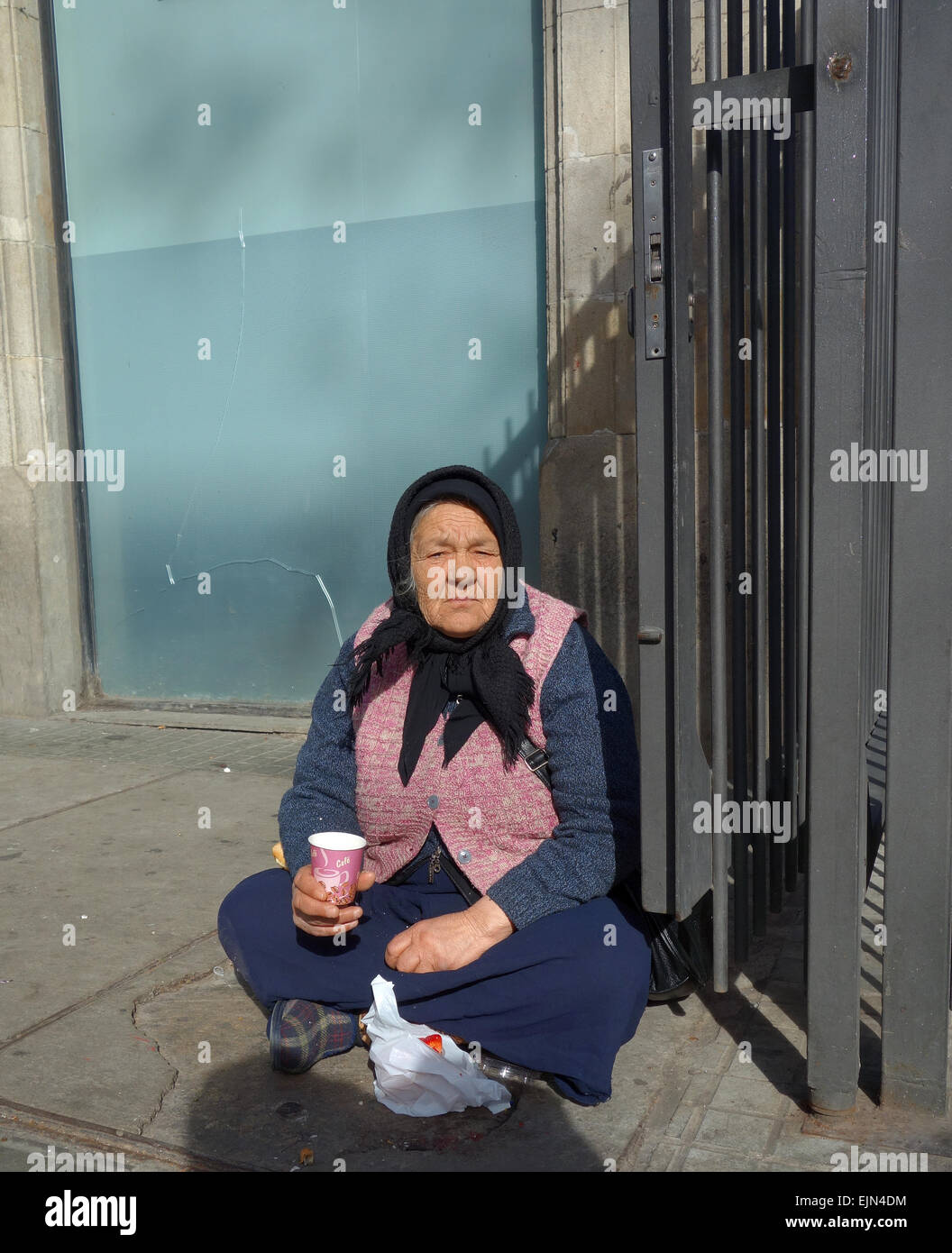 Vieille Femme assise sur le sol, la mendicité en dehors du marché de la Boqueria sur Las Ramblas à Barcelone, Catalogne, Espagne Banque D'Images
