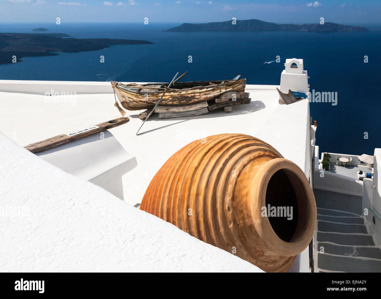 Pot en terre cuite et une vieille barque sur le toit d'un immeuble donnant sur la caldeira, Firostefani, Santorin (Théra), Grèce Banque D'Images