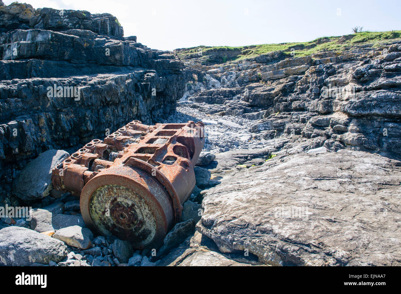 Le moteur d'un bateau se trouve la rouille sur un rivage rocailleux. Banque D'Images