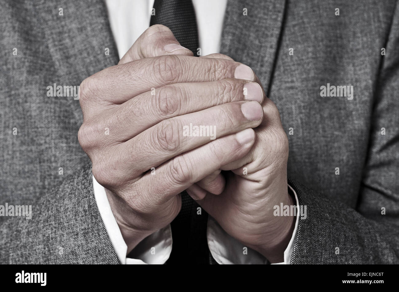 Un homme portant un costume de se frotter les mains Banque D'Images