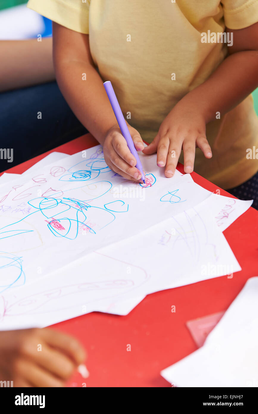 Mains de peinture de l'enfant sur une feuille de papier, un feutre à la maternelle Banque D'Images