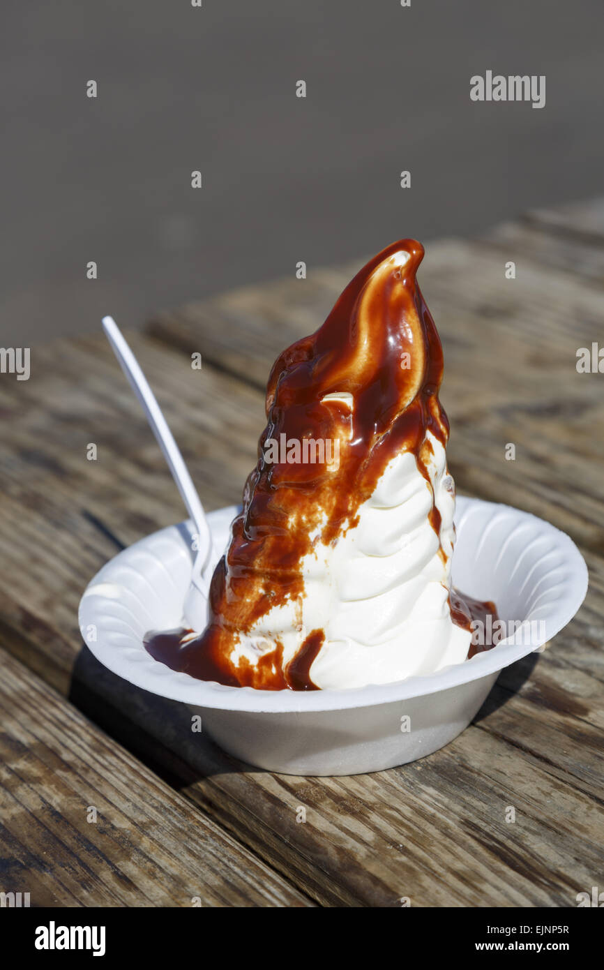 Bol de crème glacée au fondant chaud sauce sur une table en bois Banque D'Images