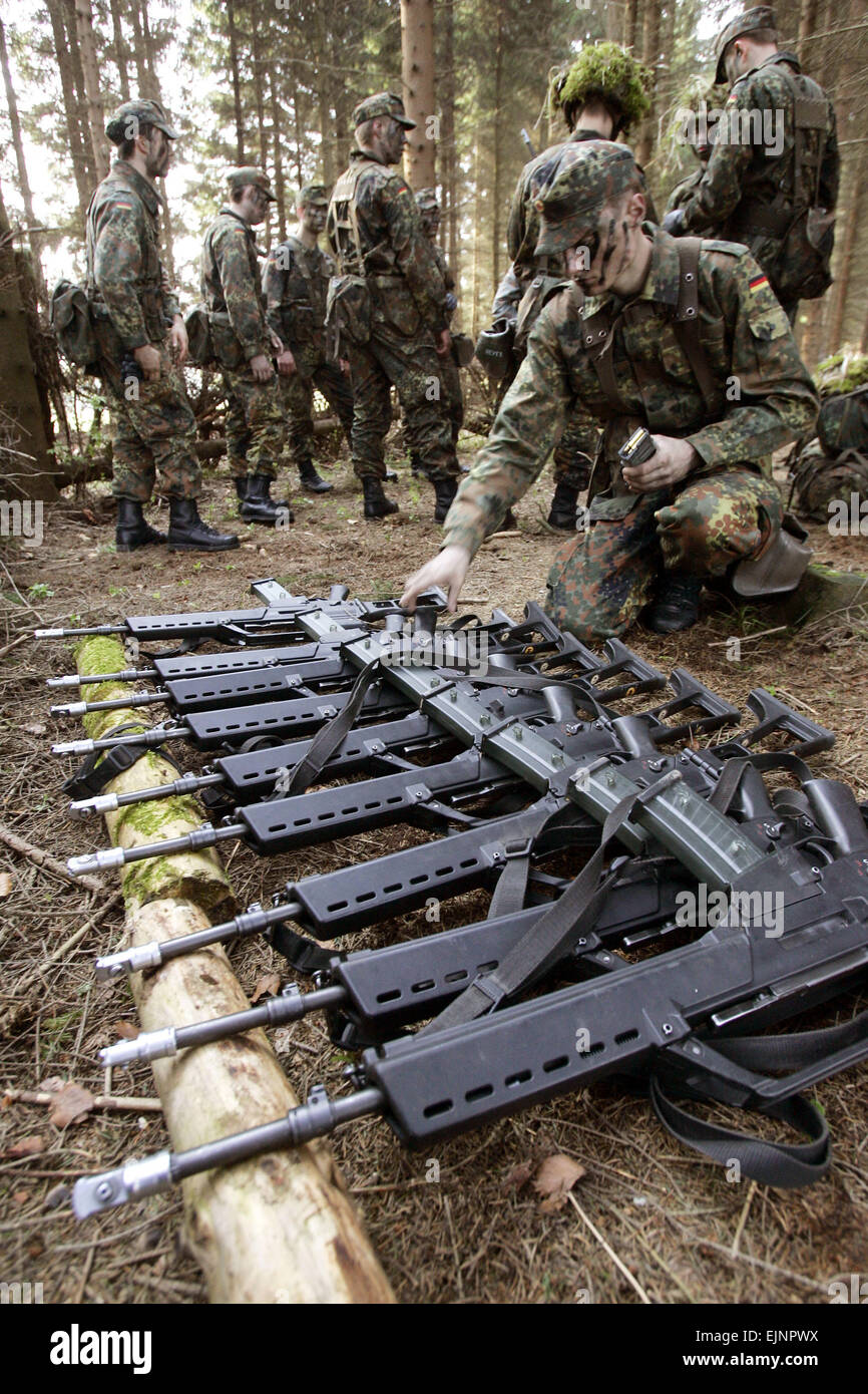 Schwarzenborn, Allemagne. 14 avr, 2005. (Afp) - Le fichier photo, datée du 14 avril 2005, montre un soldat de la Bundeswehr allemande contrôle G36 rifles portant sur le terrain pendant la formation militaire de base à la caserne en Knuell Schwarzenborn, Allemagne, 14 avril 2005. Dans l'arrière-plan un instructeur militaire indique à conscrits. © dpa/Alamy Live News Banque D'Images
