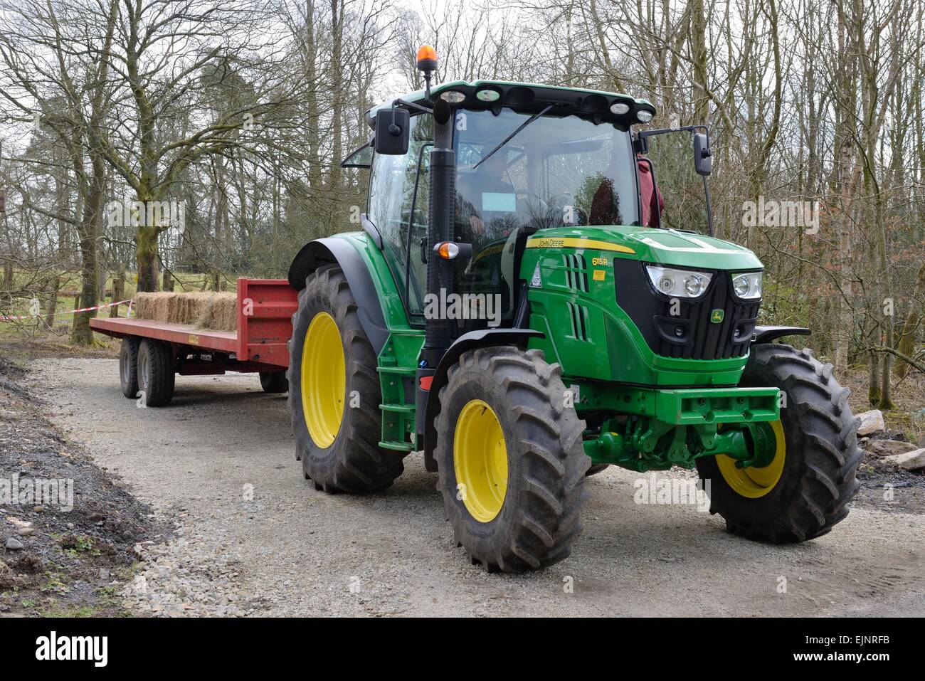 Un John Deere, vert et jaune, le tracteur tirant une remorque. Banque D'Images