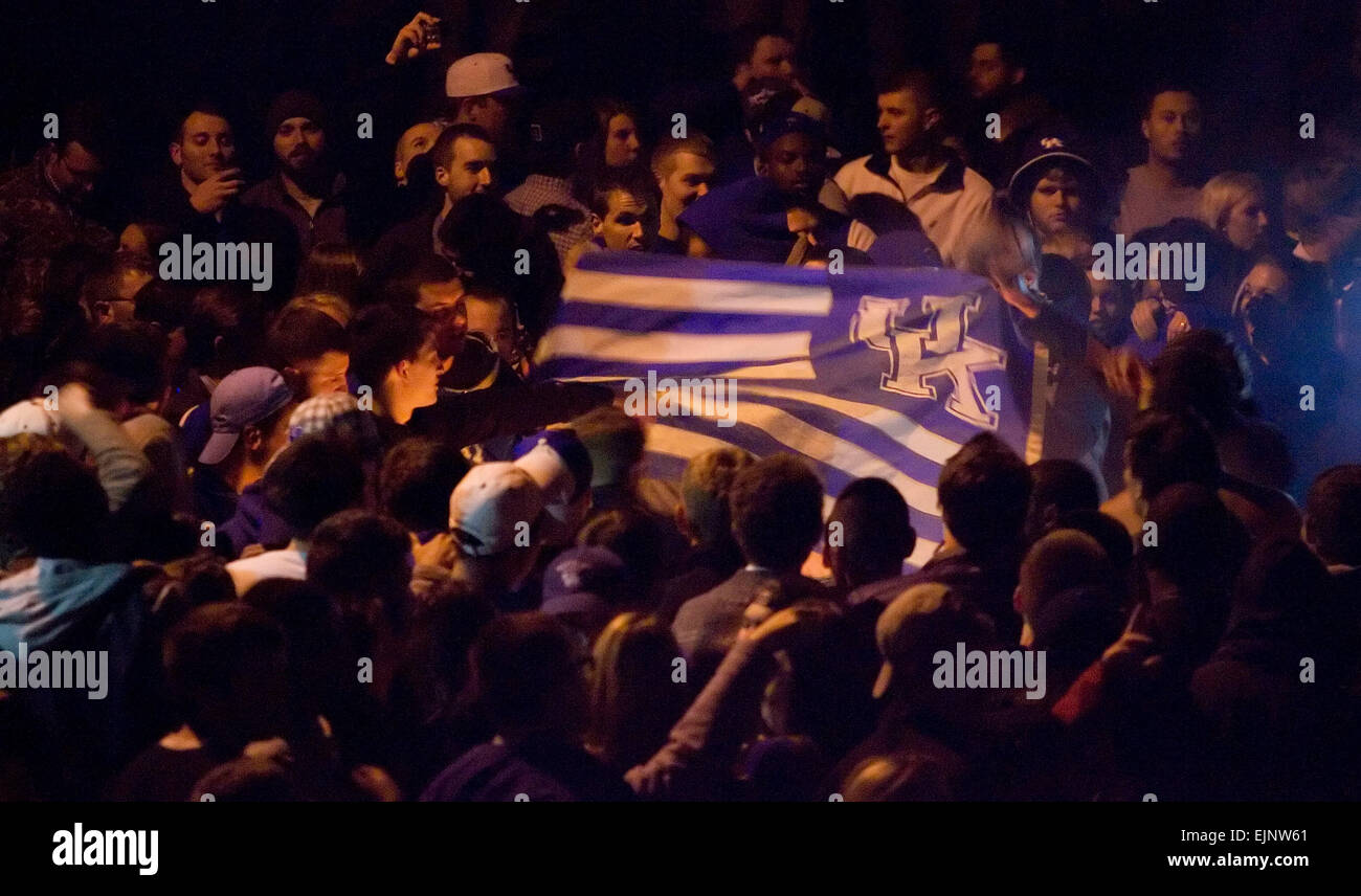 Lexington, Kentucky, USA. Mar 28, 2015. Université du Kentucky Wildcats fans recueillis le long de la State Street dance autour d'un petit incendie qui agitait un drapeau bleu et blanc UK qui célèbrent leur victoire de 68-66 de l'équipe de l'Université Notre Dame Fighting Irish de l'Élite 8 ronde de la NCAA men's basket-ball tournoi début Dimanche, 29 mars 2015 à Lexington, Kentucky, USA. Les autorités ont déclaré qu'fêtards 18 ont été arrêtés à l'échelle de la ville, la plupart d'ivresse publique ou de conduite désordonnée, sans incendies majeurs ou des blessures mortelles signalées. Credit : MediaWire Apex/Alamy Live News Banque D'Images