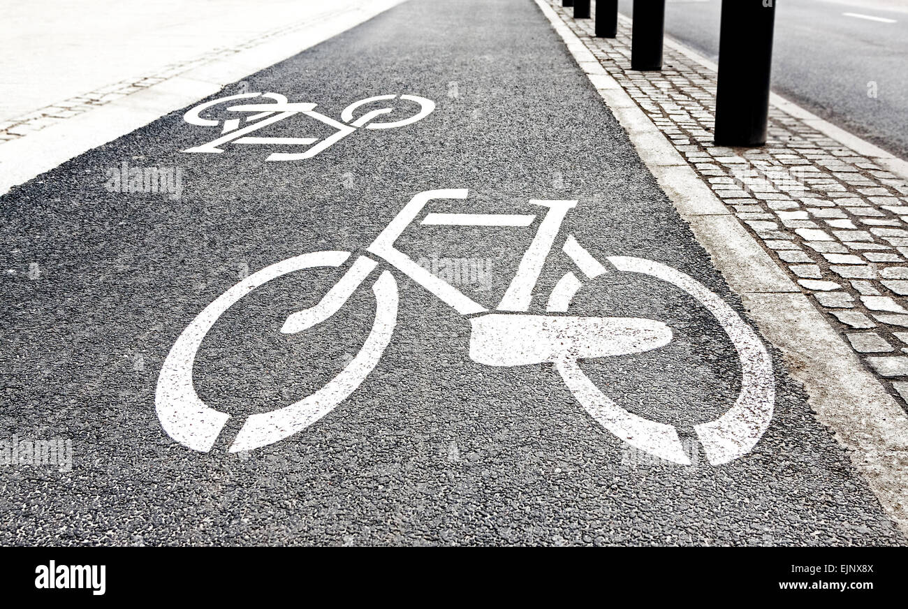Signes de piste cyclable peint en blanc sur l'asphalte. Banque D'Images