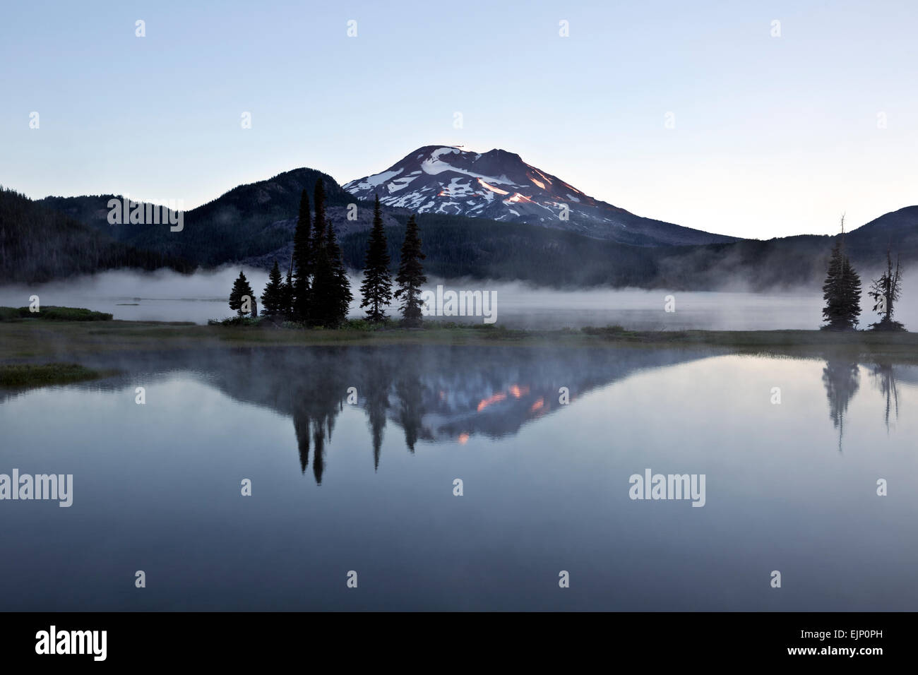 OREGON - Brume sur le lac d'étincelles et un reflet de la soeur du Sud dans le brouillard au lever du soleil dans la forêt nationale de Deschutes. Banque D'Images