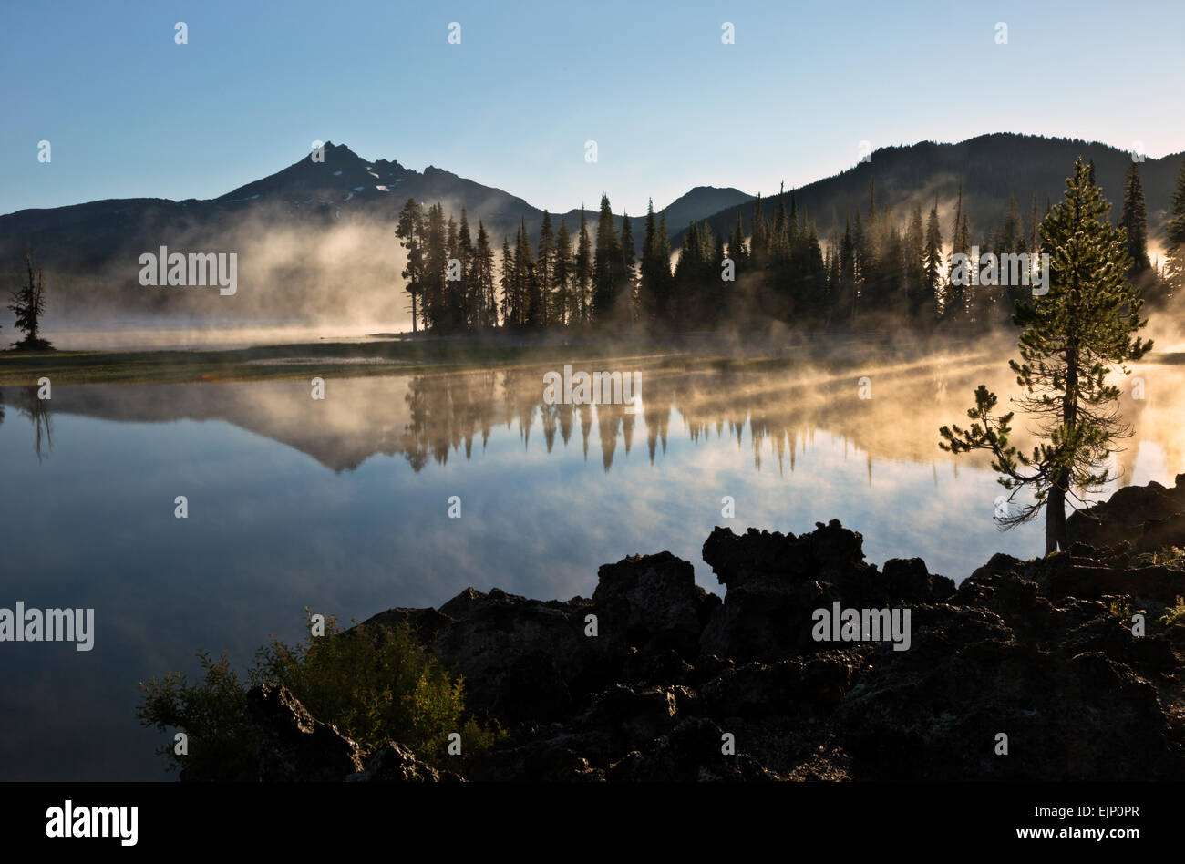 Ou01828-00...OREGON - solaires frappant la brume sur le lac d'étincelles à cassé haut au-delà de la Forêt Nationale de Deschutes près de Bend. Banque D'Images