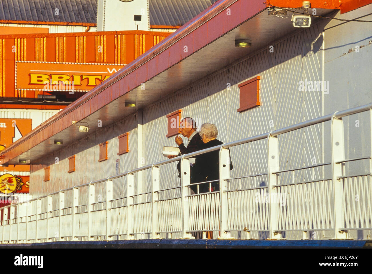 A mature couple Eating fish and chips sur Britannia Pier. Great Yarmouth. Le Norfolk. L'Angleterre. UK Banque D'Images