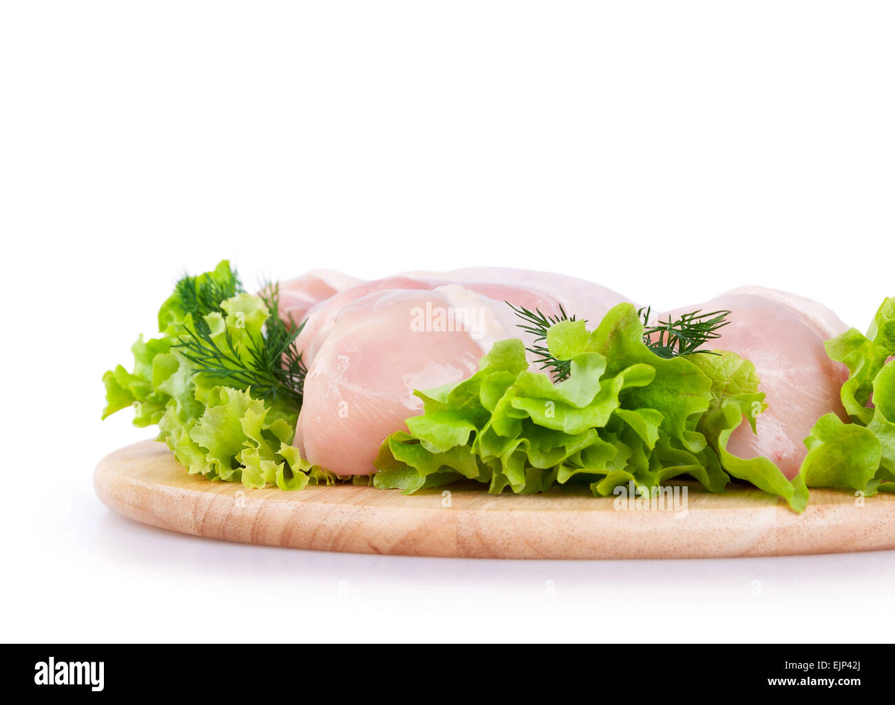 La viande de poulet crue avec une salade verte sur une planche en bois Banque D'Images