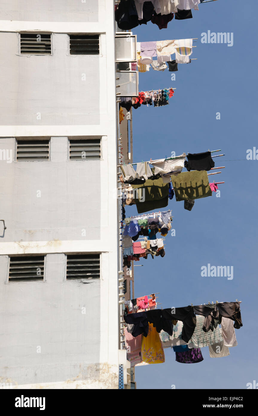 Le séchage des vêtements dans certains ménages de Singapour implique de pendre des vêtements hors de leur logement fenêtre plate sur un poteau en bambou. Banque D'Images