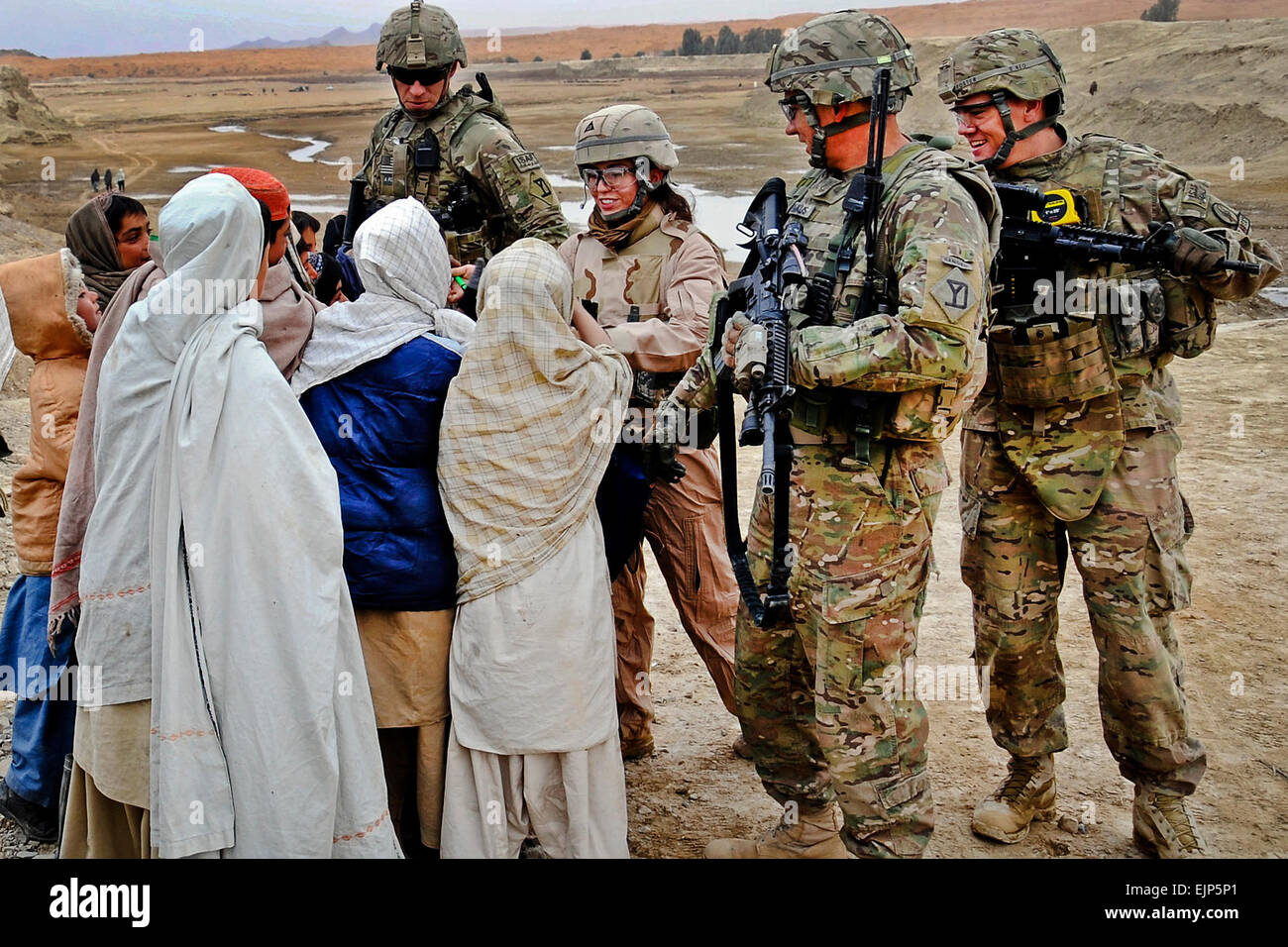 Membre de l'Équipe de reconstruction provinciale de Kandahar part des stylos pour les enfants afghans lors d'une évaluation du site du barrage de contrôle Dot Rud. L'équipe travaille avec des fonctionnaires du gouvernement au niveau du district et de la province de construire la capacité de l'infrastructure durable. Banque D'Images