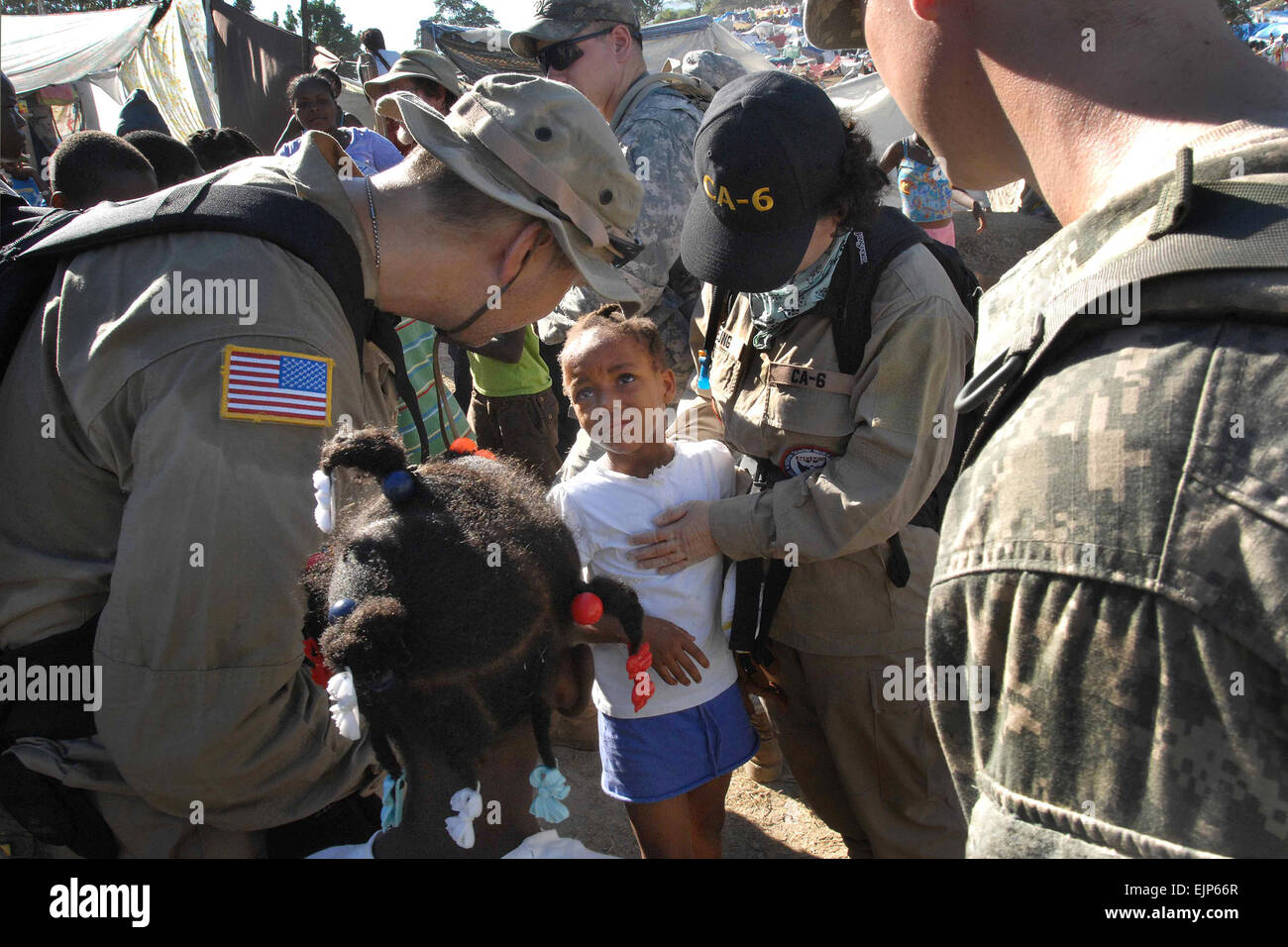 Les soldats de l'armée américaine et professionnels de la médecine d'autres organismes de secours à pied à travers le survivant au pied de leur base d'opérations avancée de Port-au-Prince, Haïti, 21 janvier 2010. Les soldats sont affectés à la 82nd Airborne Division, 1er Escadron, 73e Escadron de cavalerie. Fred W. Baker III Banque D'Images