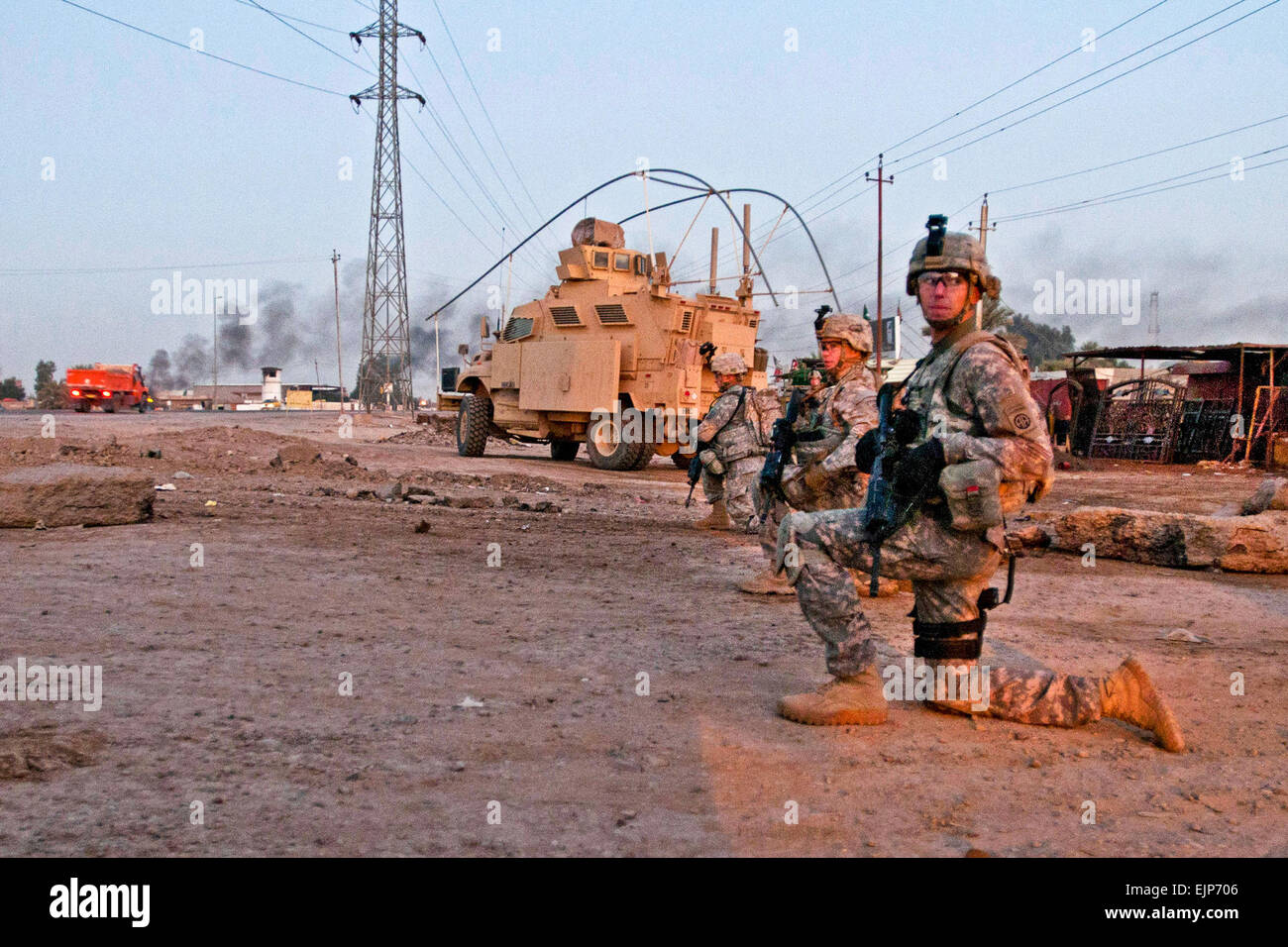 La police militaire affecté au 2ème Bataillon de la brigade de troupes spéciales, 2e Brigade, 82e Division aéroportée, prendre un genou lors d'une patrouille à pied le long d'une route à l'extérieur, l'Iraq, Camp Taji 2 décembre. Les députés mis en place longtemps avant le lever du soleil à patrouiller les routes à l'extérieur du camp pour assurer la sécurité des convois 2/82 qui voyagent à travers la région de Bagdad. La 2e Brigade est la dernière brigade dans Bagdad et facilite le retrait des forces militaires américaines de l'Iraq. Banque D'Images