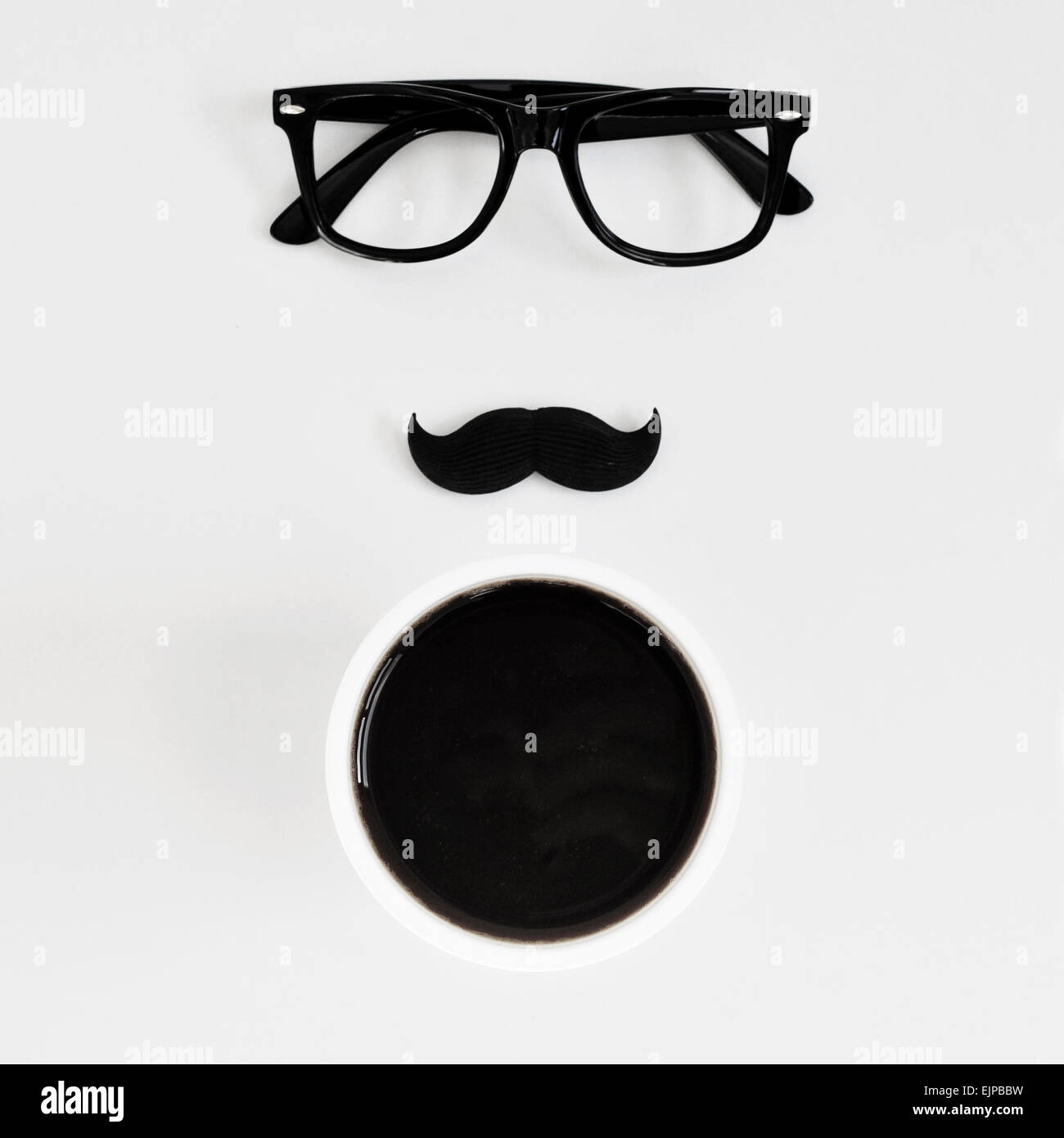 Capture d'un grand angle d'un tableau blanc avec une paire de lunettes cerclées de noir en plastique, une fausse moustache et une tasse de café, représentant Banque D'Images