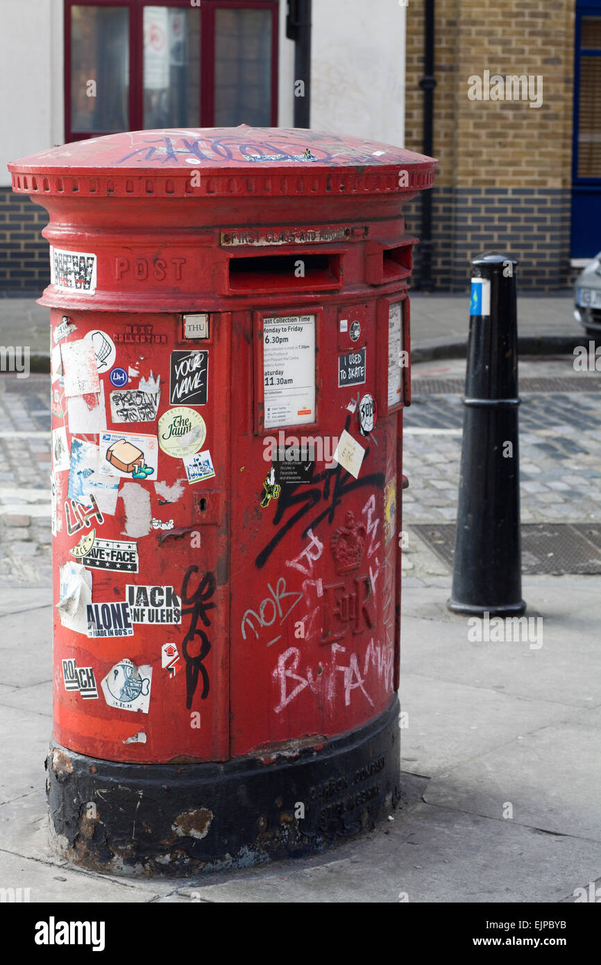 Graffitis et autocollants sur un vieux post box à Londres en Angleterre Banque D'Images