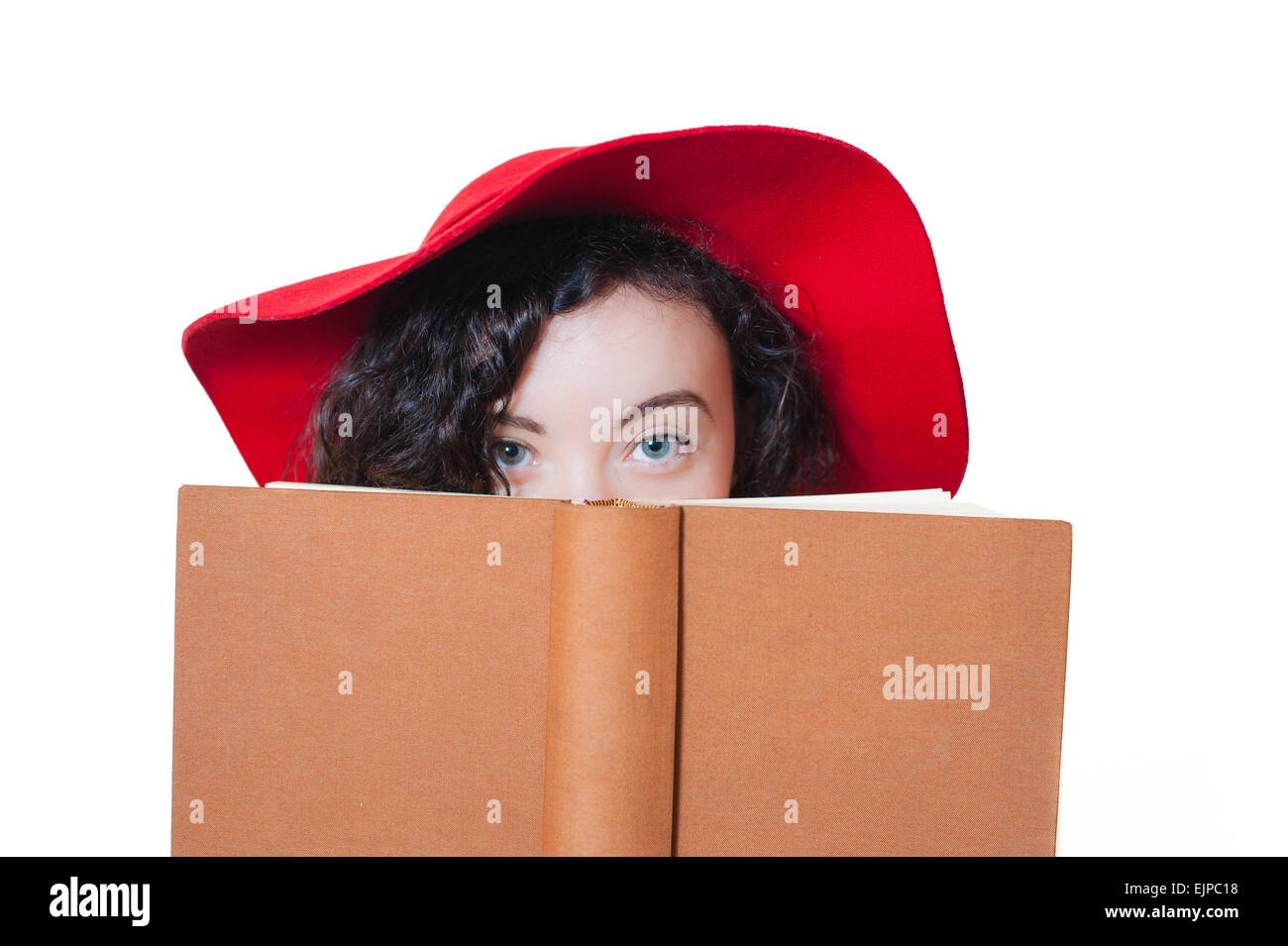 Jeune femme avec red hat holding book partiellement couvert le visage, yeux bleus isolé sur fond blanc Banque D'Images