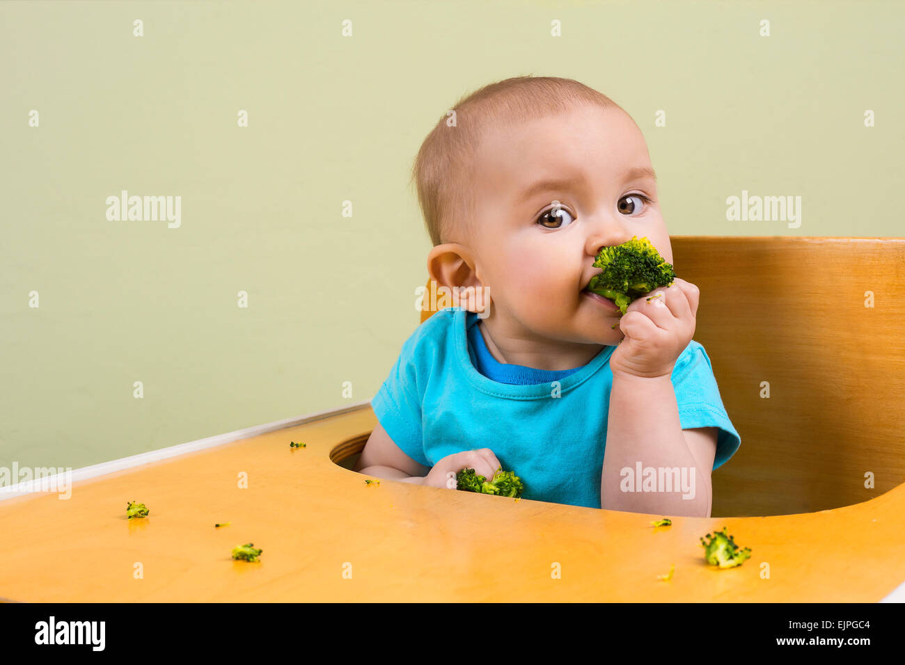 Mignon bébé manger le brocoli Banque D'Images