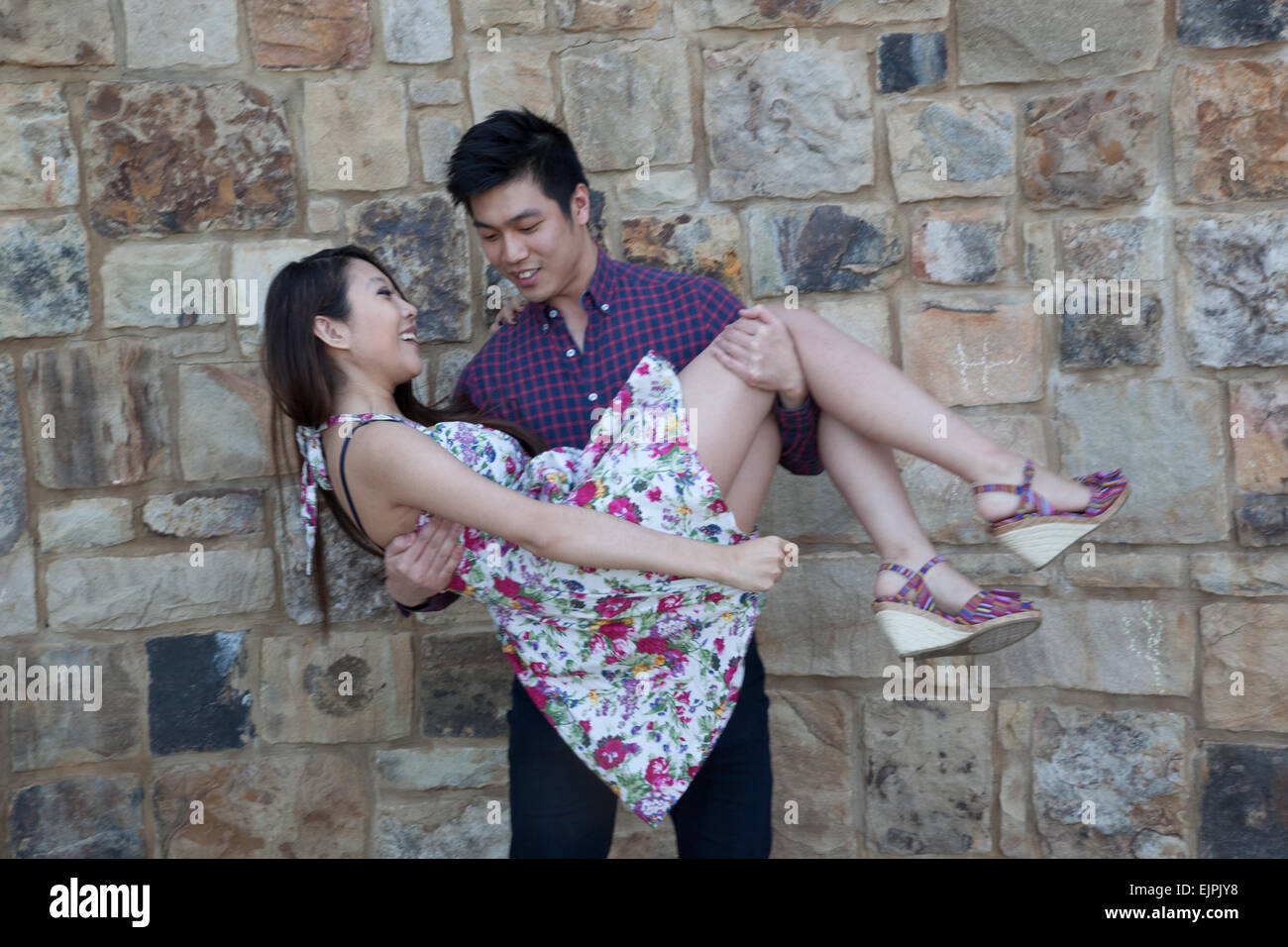 Asiatique romantique couple outdoors, femme et homme, il tient dans ses bras Banque D'Images