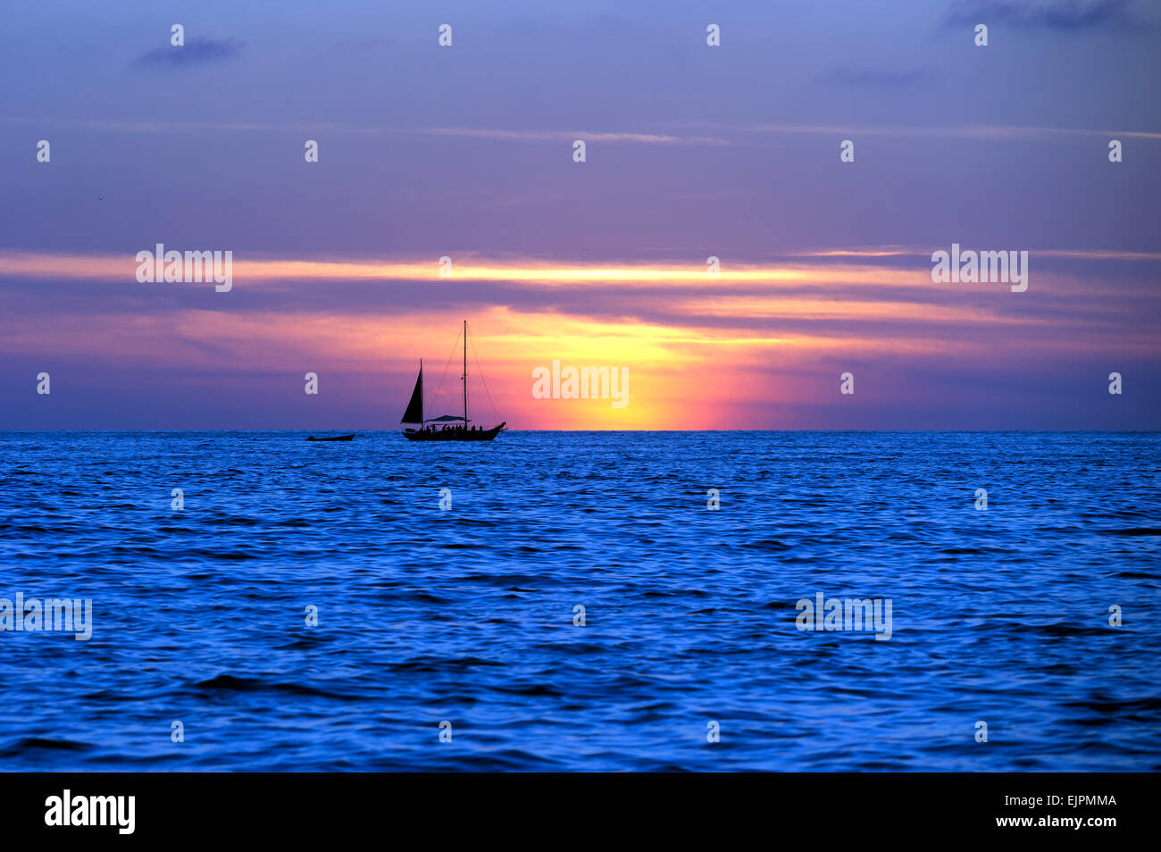 Un voilier est découpé sur un ciel de coucher du soleil. Banque D'Images