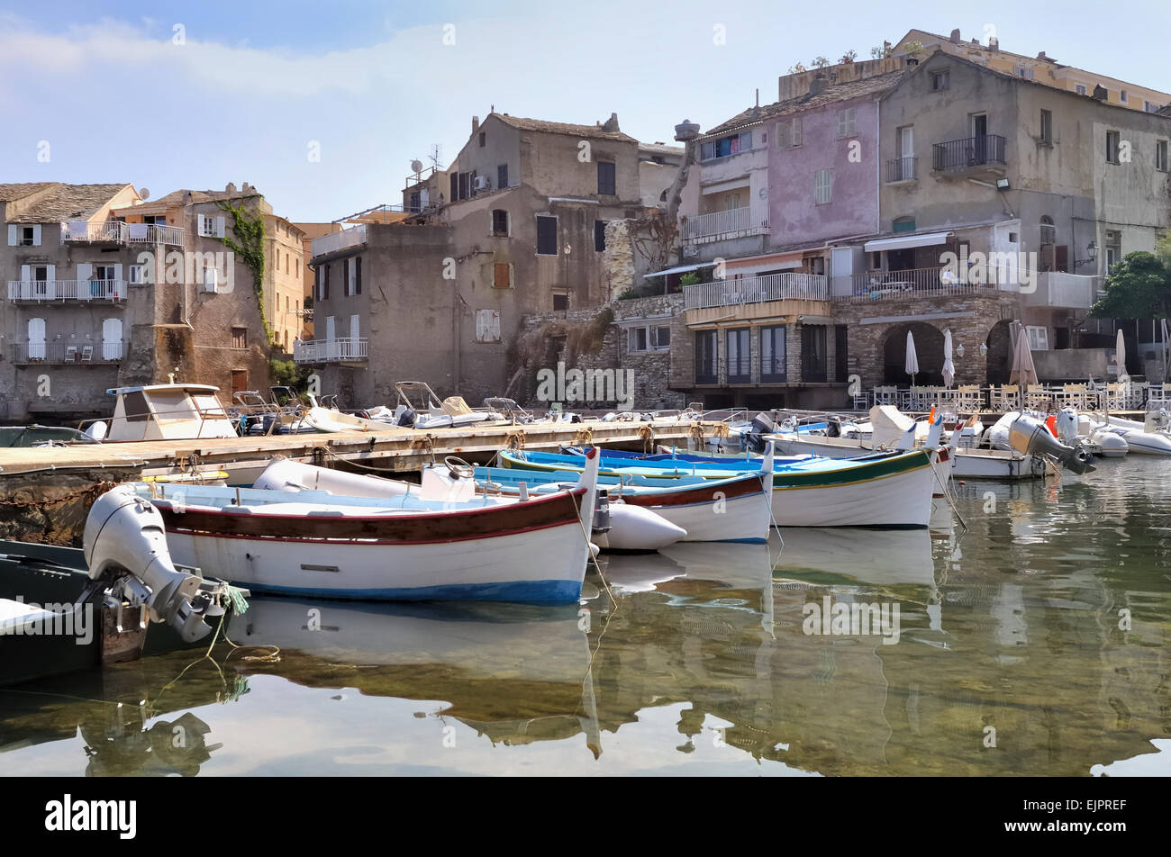 De petites embarcations et façades de maisons s'est évanoui dans un port en Corse Banque D'Images