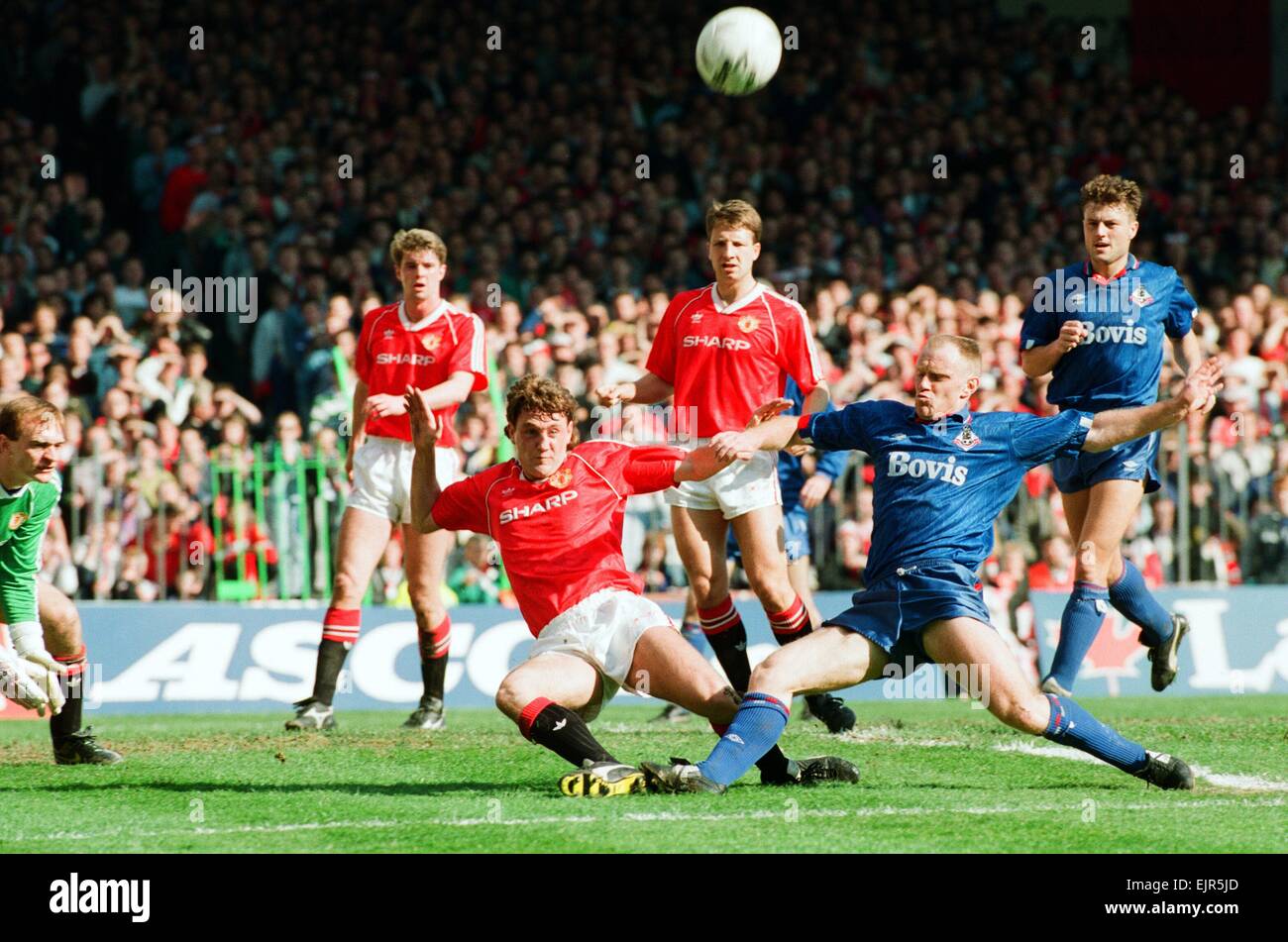 Steve Bruce tente de garder hors Andy Ritchie. FA Cup. Manchester United 3 Oldham Athletic v 3. 8 avril 1990 Banque D'Images