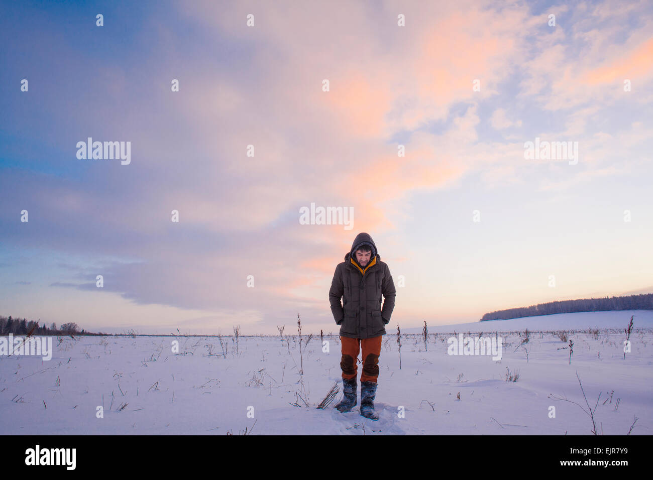 Mixed Race man walking in snowy field Banque D'Images