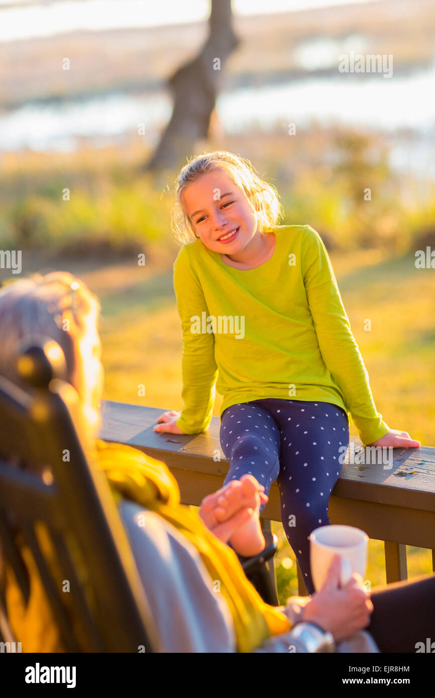 Grand-mère de race blanche et petite-fille de détente sur porche Banque D'Images