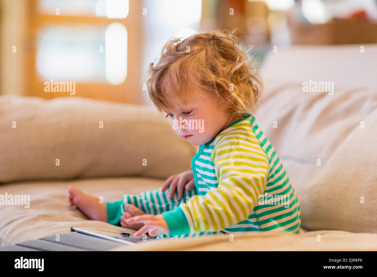 Caucasian baby boy sitting on sofa Banque D'Images