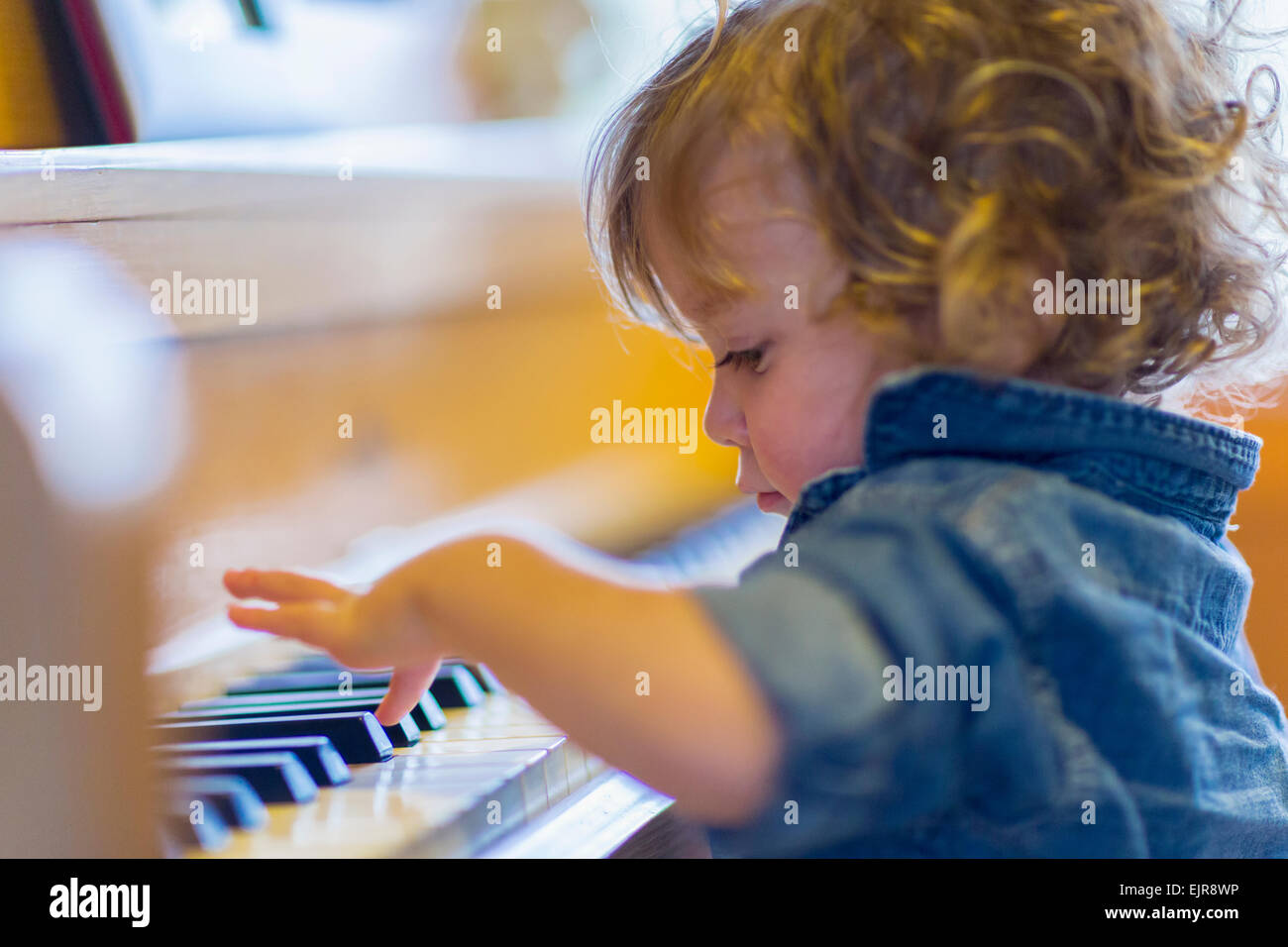 Caucasian baby boy playing piano Banque D'Images