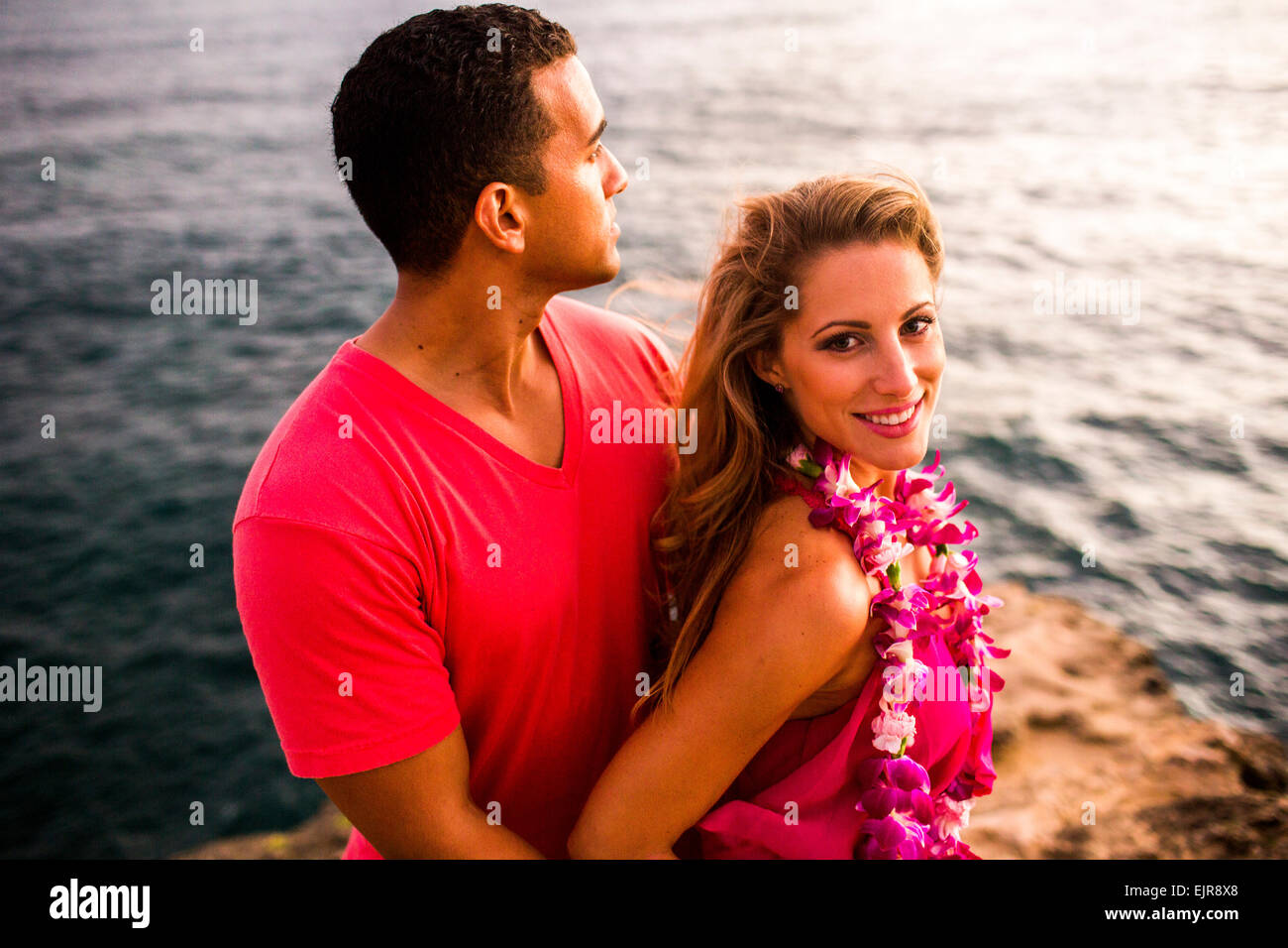 Smiling couple hugging on rocks sur l'océan Banque D'Images