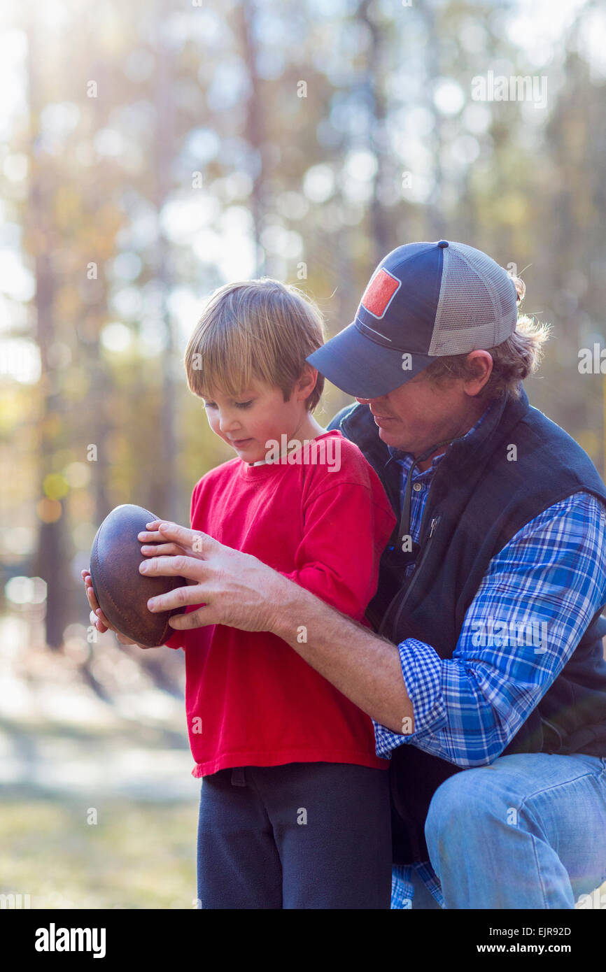 Woman teaching son to play football Banque D'Images