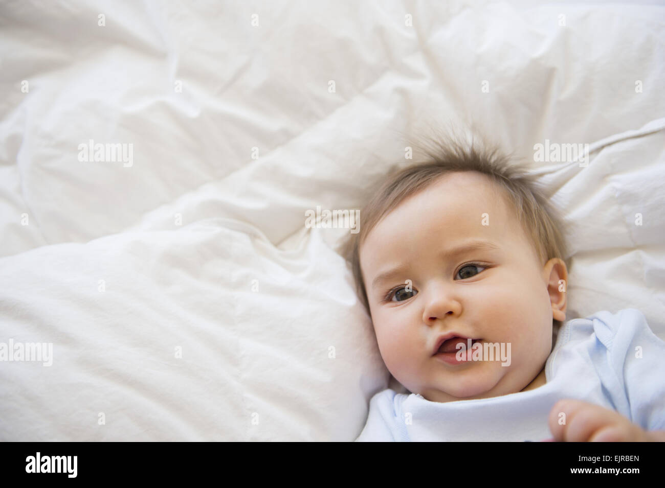 Close up of mixed race baby laying on bed Banque D'Images