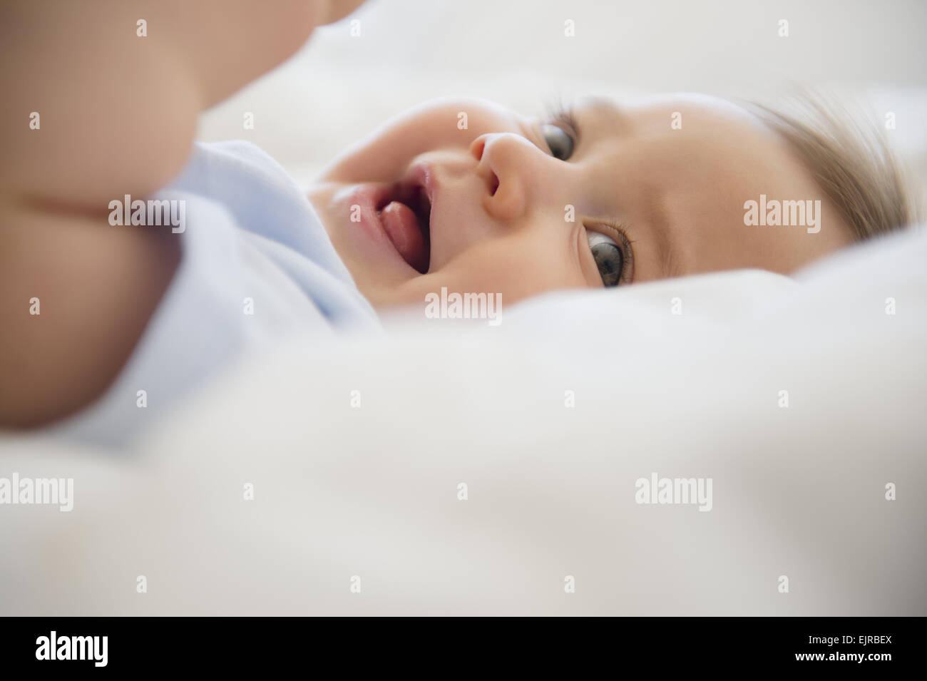 Close up of mixed race baby laying on bed Banque D'Images